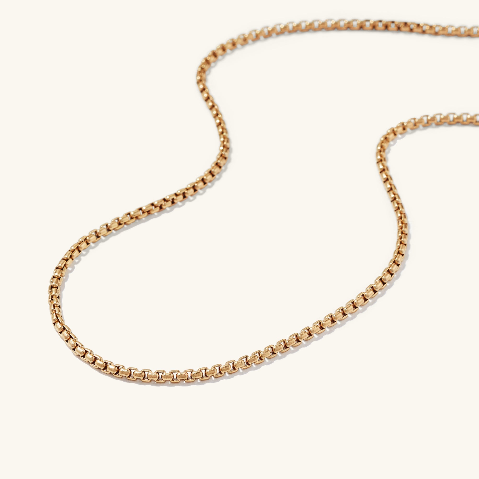 Round Box Chain Necklace on a white surface; a versatile gold chain thatâs perfect for everyday wear, complementing the Round Box Chain Bracelet.