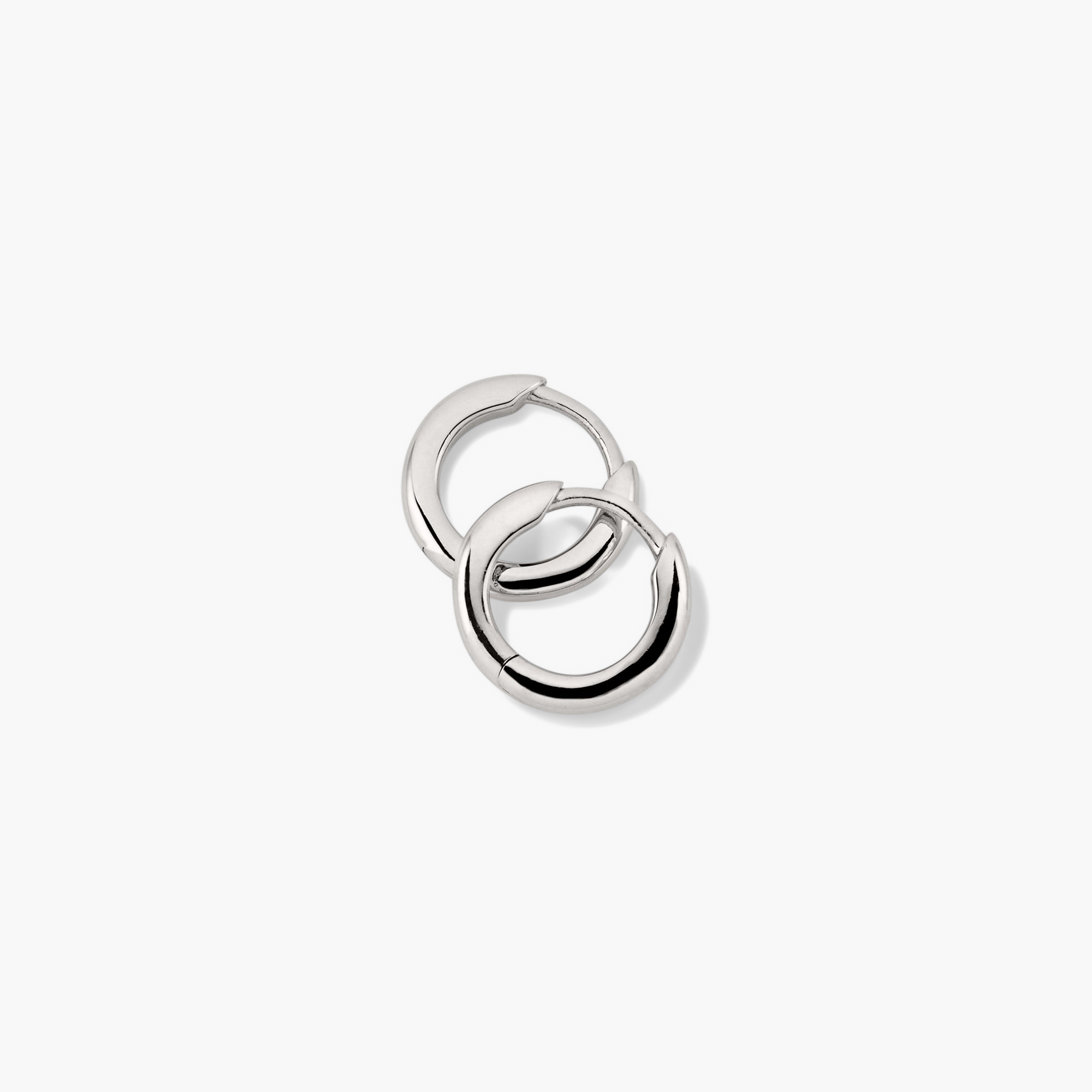 Tube Huggie Hoops: A close-up of lightweight, bold silver hoop earrings with a clicker closure, offering a modern tube design for comfort and security.