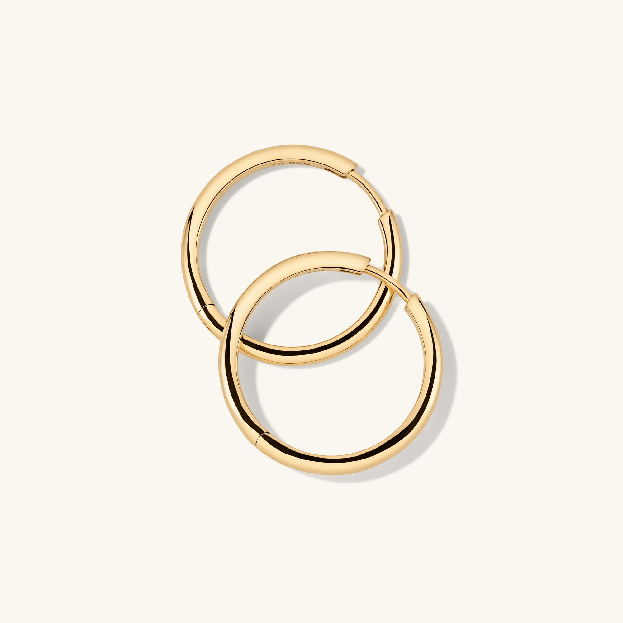 Tube Large Hoops: Lightweight gold hoop earrings with a clicker closure, designed for modern comfort and effortless wear.