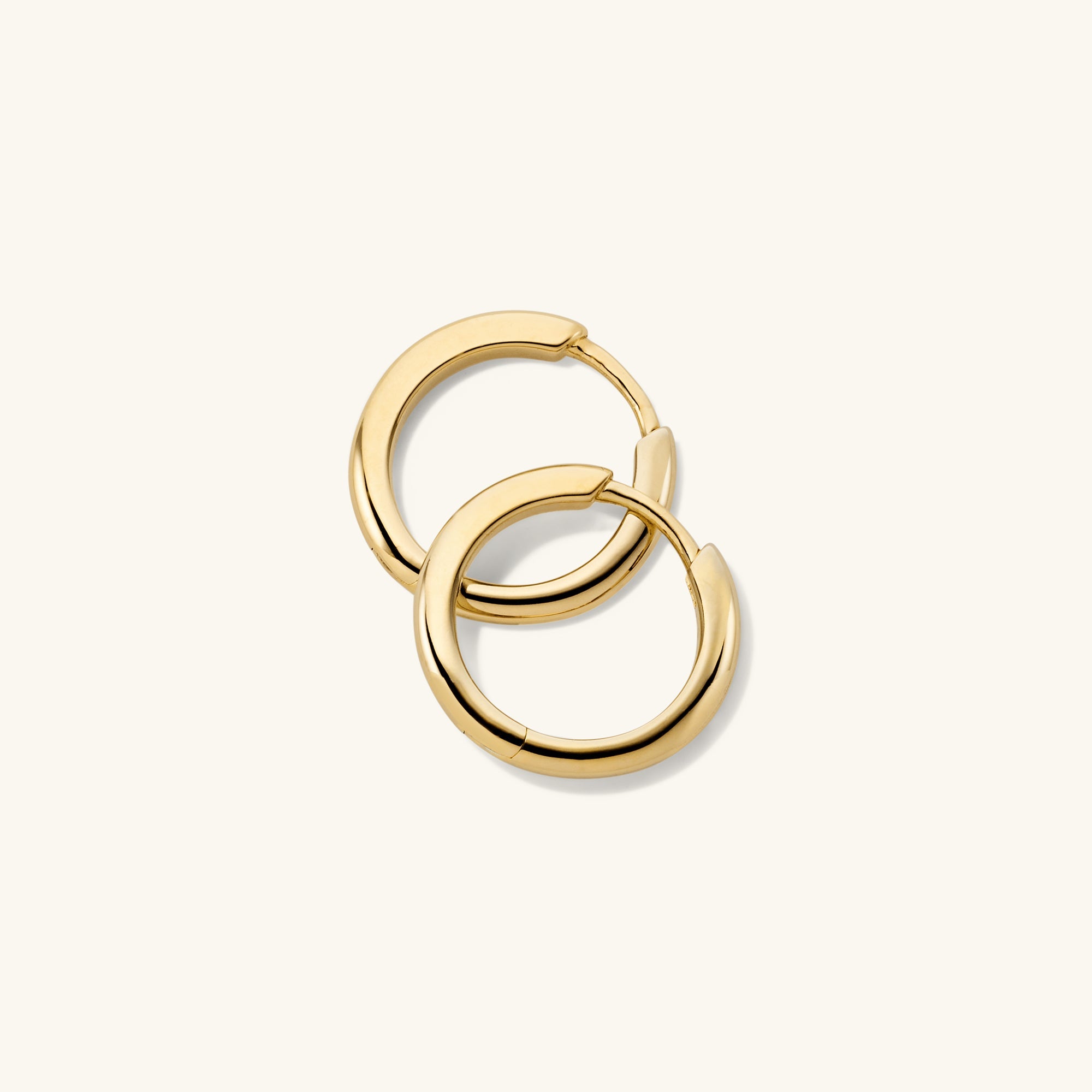 Tube Medium Hoops: A pair of modern gold hoop earrings with a bold, tubular design and clicker closure for comfort and security.