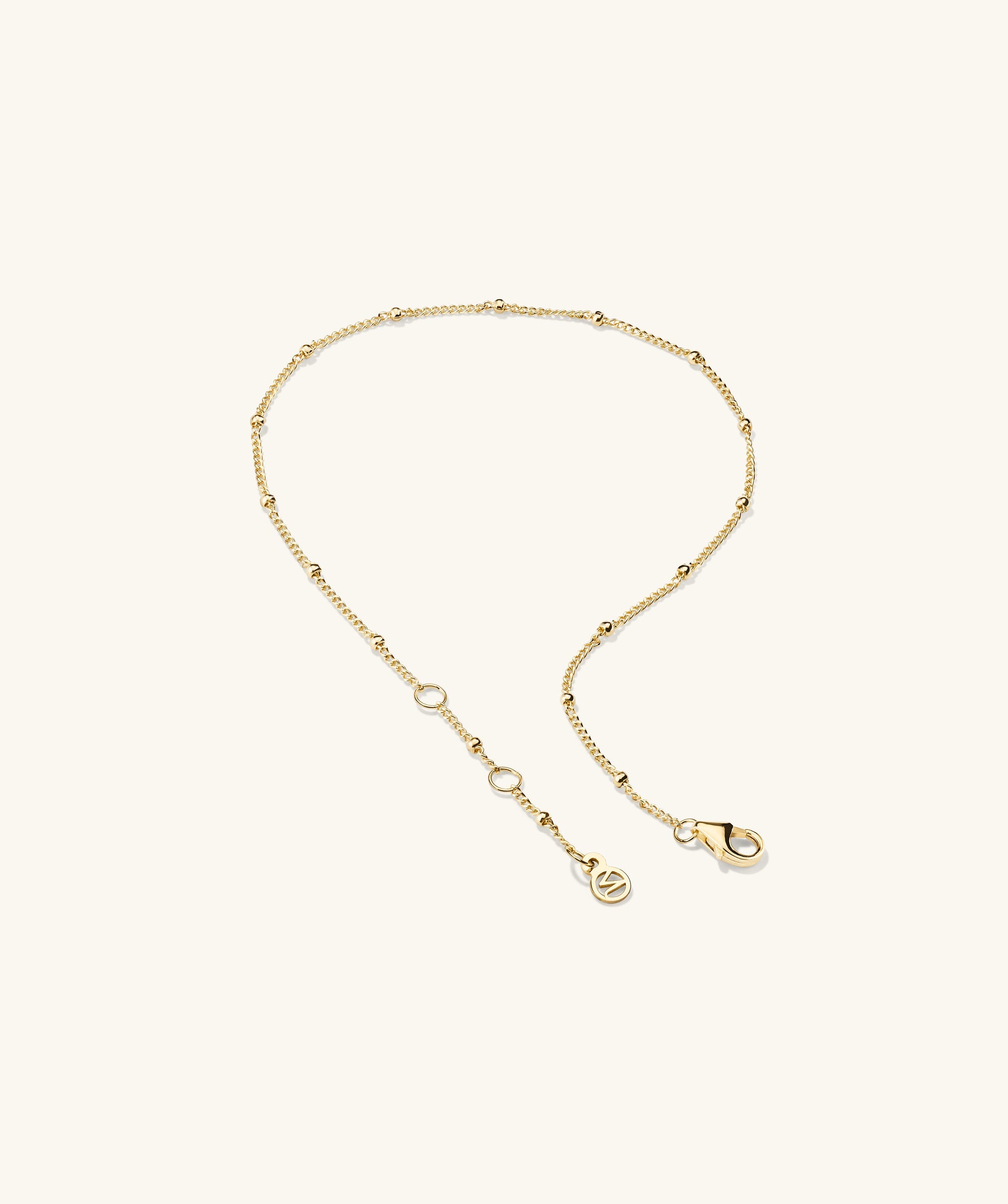 Spheres Bracelet: A minimalist gold chain bracelet with a clasp, featuring small round beads. Versatile for any outfit and occasion.