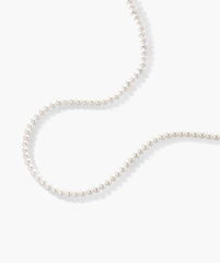Paradigm Pearl Necklace: A handcrafted string of freshwater pearls with a sterling silver clasp, displayed on a white surface.