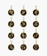 Cosmic Pendant Necklace featuring twelve round pendants with gold zodiac symbols on black enamel, accented with small gemstone stars, representing each astrological sign.