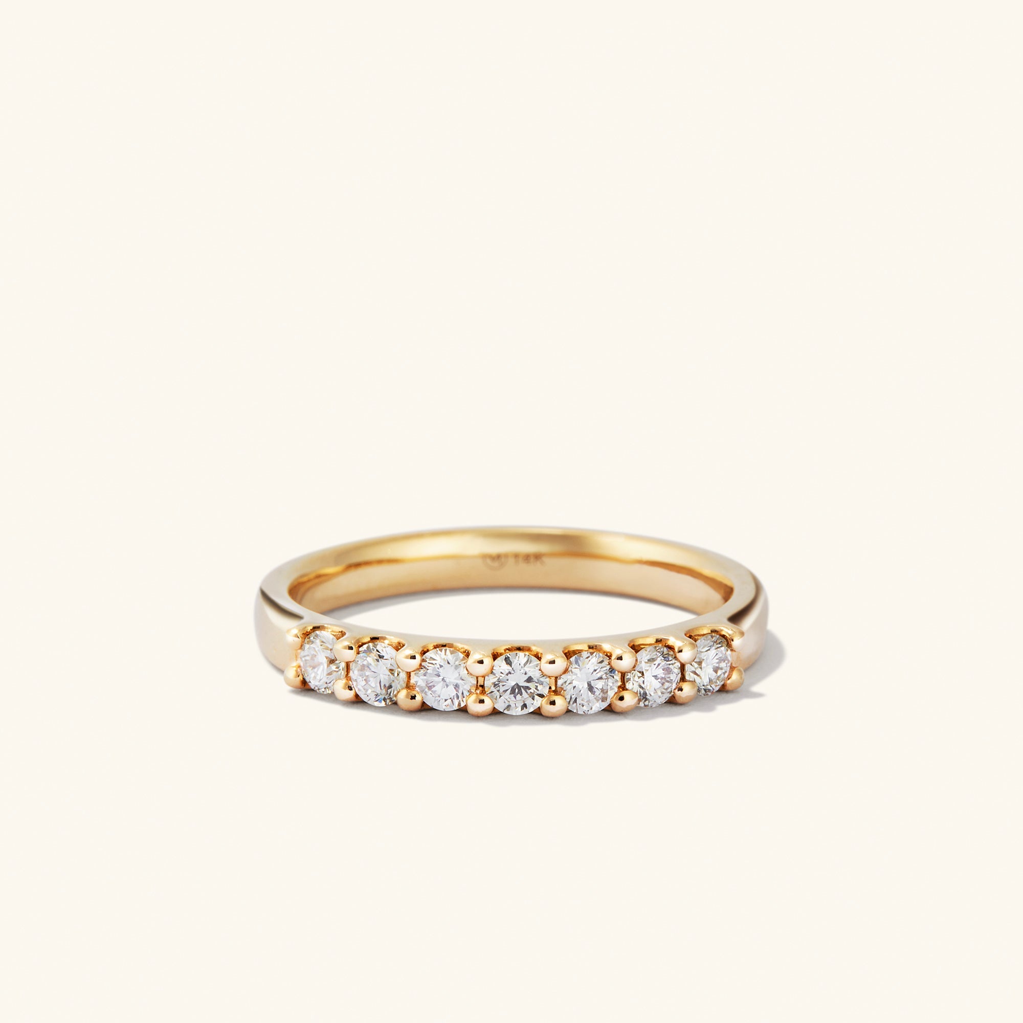 Bold Diamond Half Eternity Ring: a close-up of a 14k gold ring with seven round cut diamonds. Perfect for stacking with the Bold Diamond Eternity Ring.