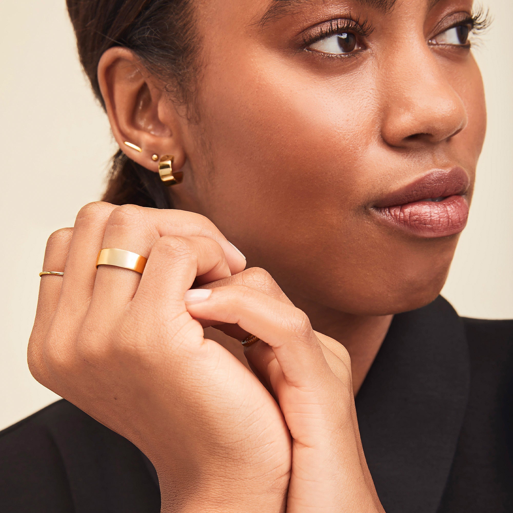 Close-up of a woman showcasing the Daily Stacker Ring on her finger, highlighting the elegant gold band as a focal fashion accessory.