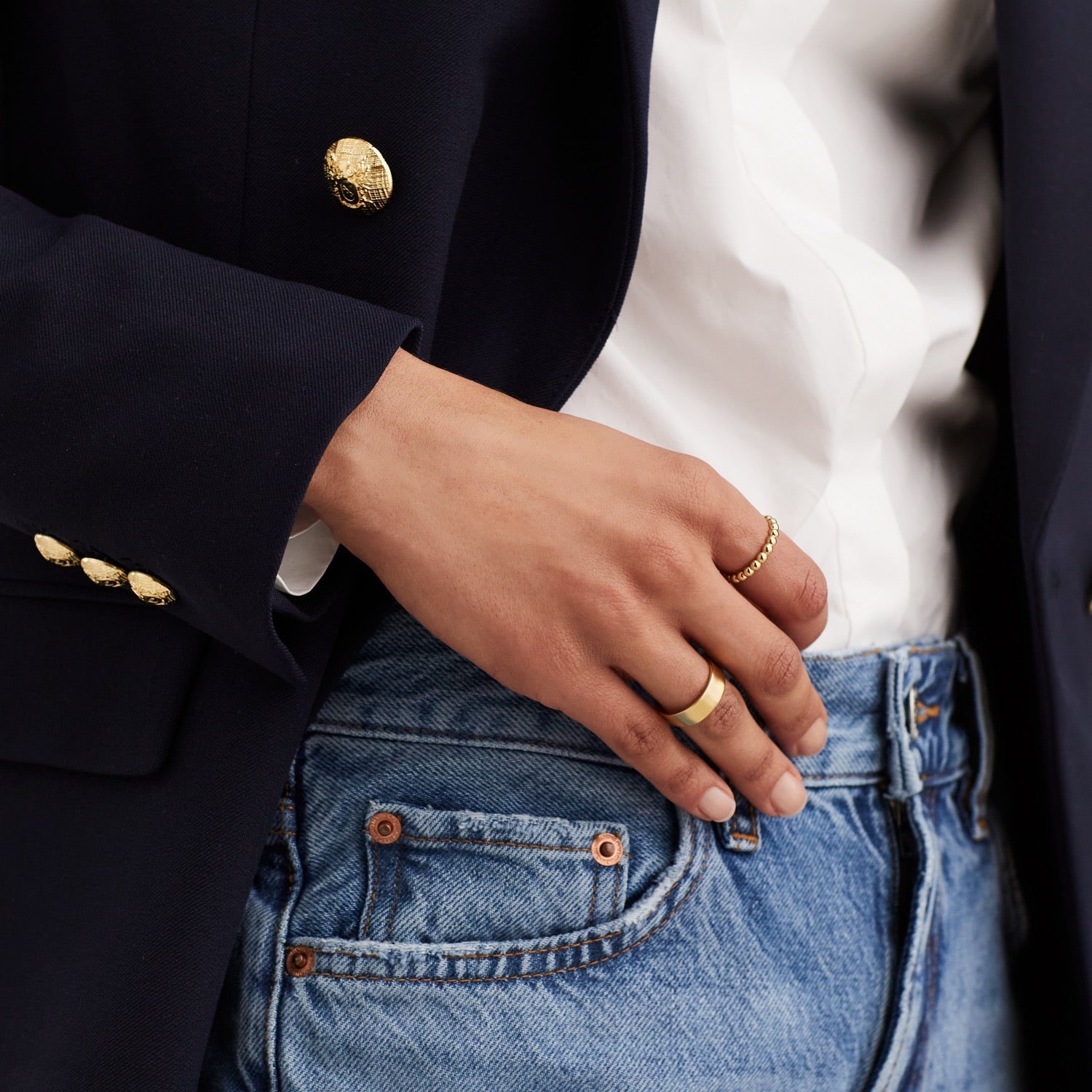 A person wearing a suit jacket displays the Metallic Sphere Ring in 18k gold vermeil, highlighting its bold, handcrafted design.