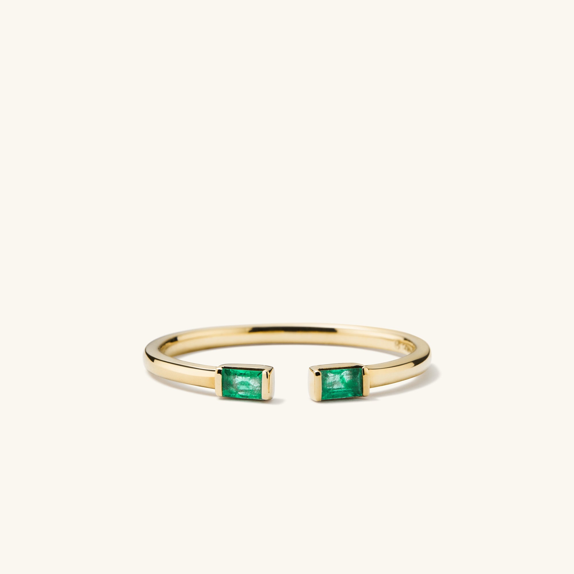 Baguette Emerald Open Ring: A close-up of a gold ring featuring handcrafted emerald baguettes with unique inclusions, highlighting its intricate design and responsibly sourced gemstones.