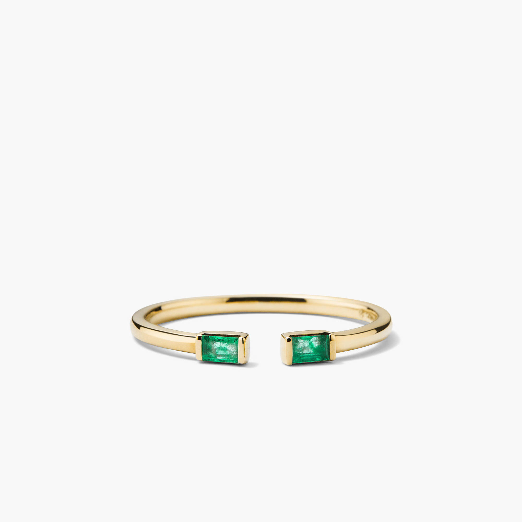 Baguette Emerald Open Ring: A close-up of a gold ring featuring handcrafted emerald baguettes with unique inclusions, highlighting its intricate design and responsibly sourced gemstones.