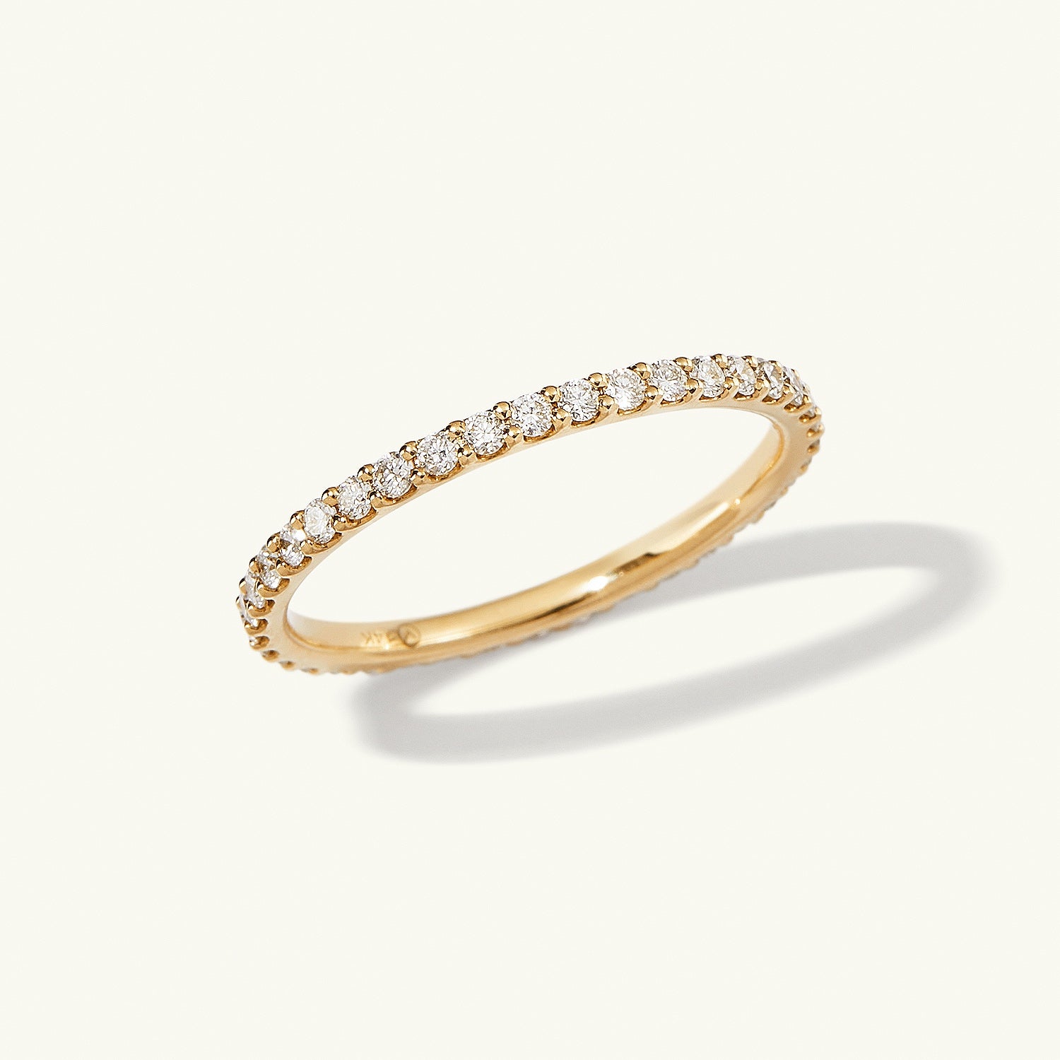 Diamond Eternity Band: A close-up of a slim 14k gold ring, featuring multiple hand-set diamonds in open prongs, showcasing brilliant sparkle.