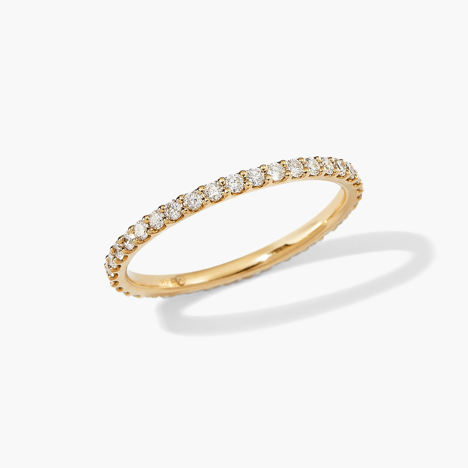 Diamond Eternity Band: A close-up of a slim 14k gold ring, featuring multiple hand-set diamonds in open prongs, showcasing brilliant sparkle.