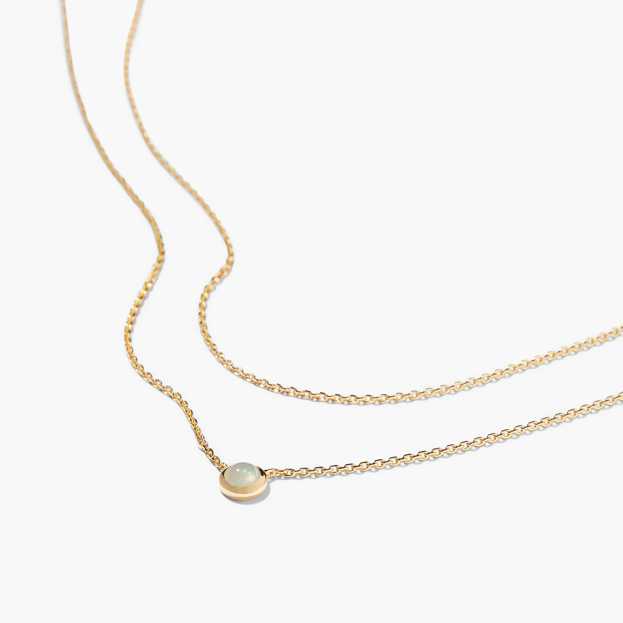 Layered Opal Necklace featuring a gold chain with a natural opal pendant in the center.