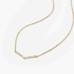 PavÃ© Diamond Wishbone Necklace: A 14k gold necklace featuring a wishbone pendant with 13 pavÃ© diamonds, on an adjustable 15-17 inch cable chain.