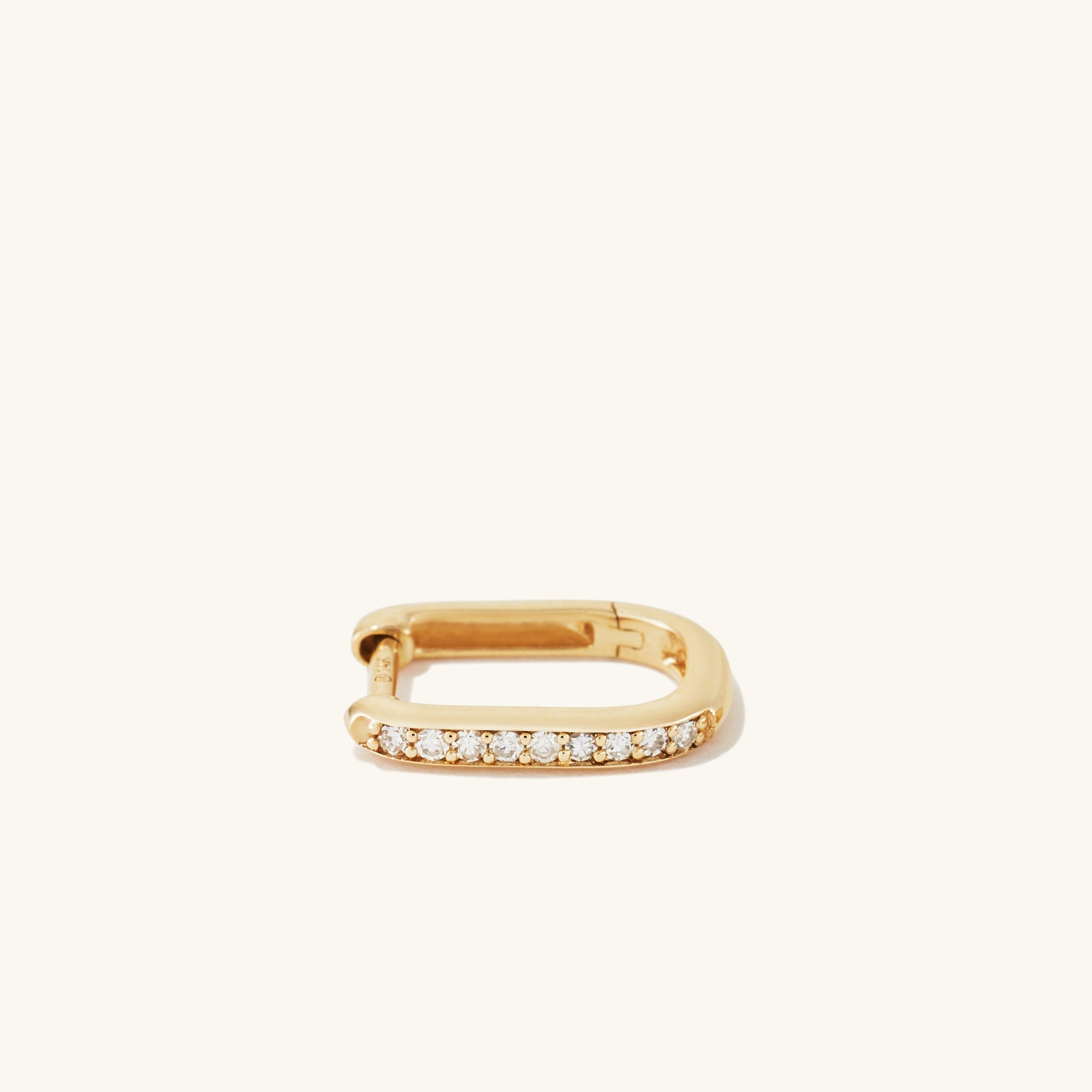Single PavÃ© Diamond Huggie U Hoop: A gold earring with a U-shaped hoop adorned with sparkly, responsibly sourced diamonds, adding dimension to an ear stack.