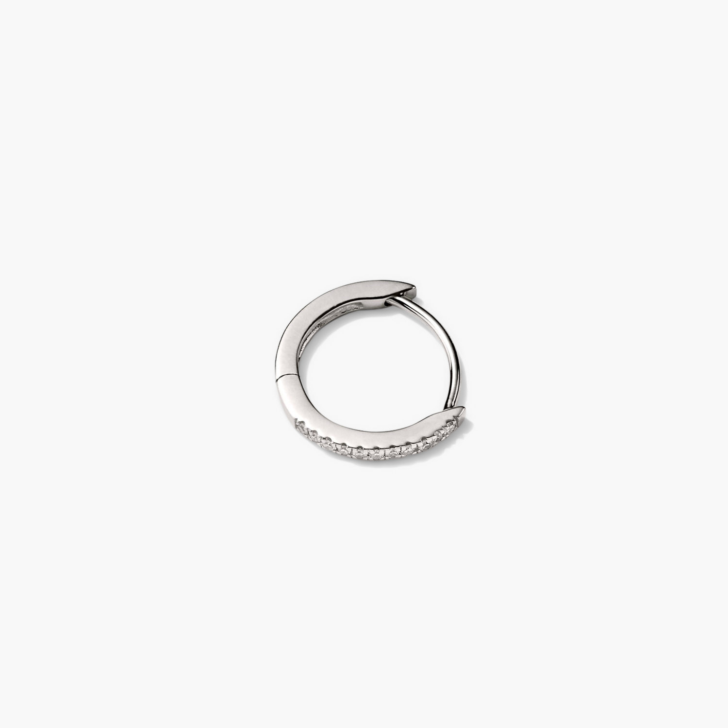 Single PavÃ© Diamond Huggie Hoop: A close-up of a silver earring with diamonds, showcasing a handcrafted design in recycled 14k solid gold. Perfect for versatile styling.