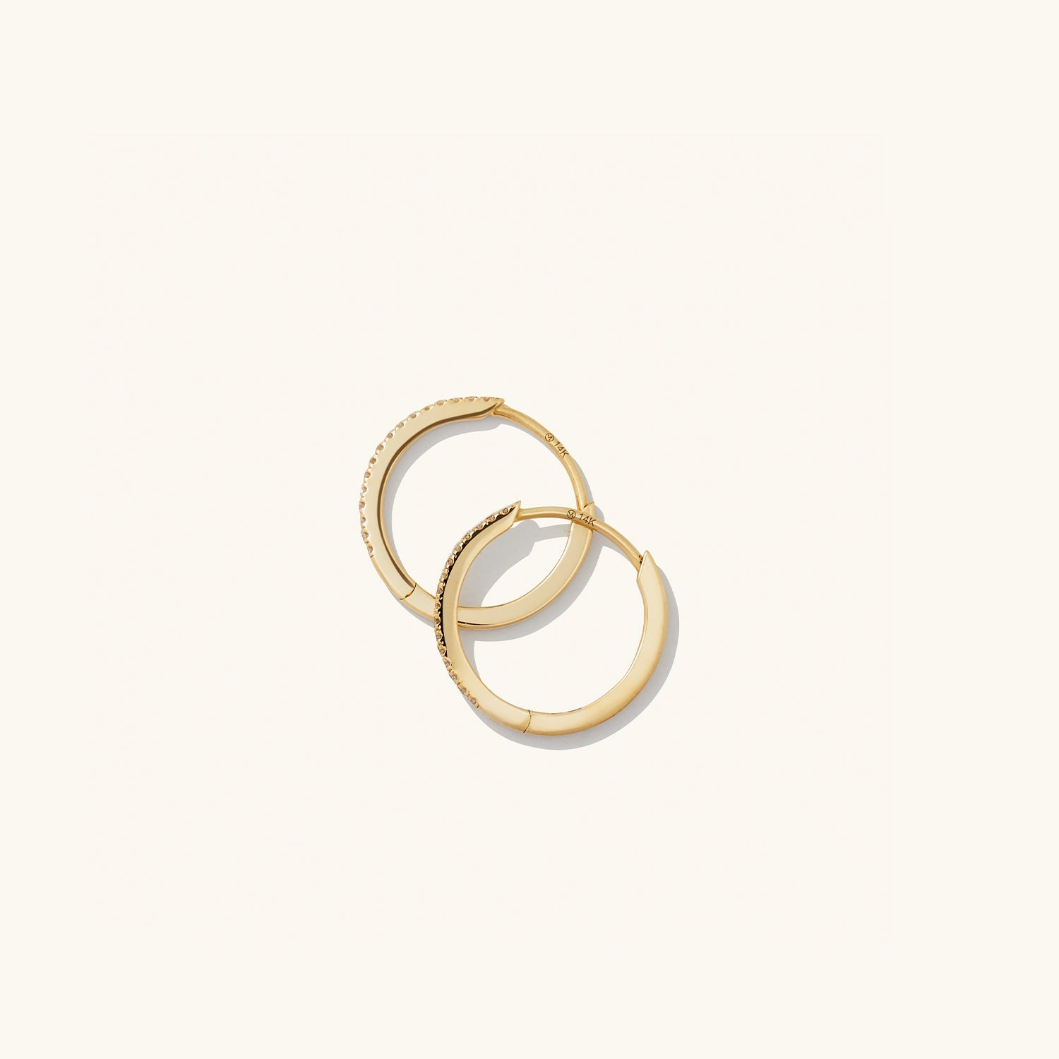 PavÃ© Diamond Small Hoops: Handcrafted 14k solid gold earrings, featuring pavÃ© diamonds on one side and a sleek finish on the other, versatile for any look.