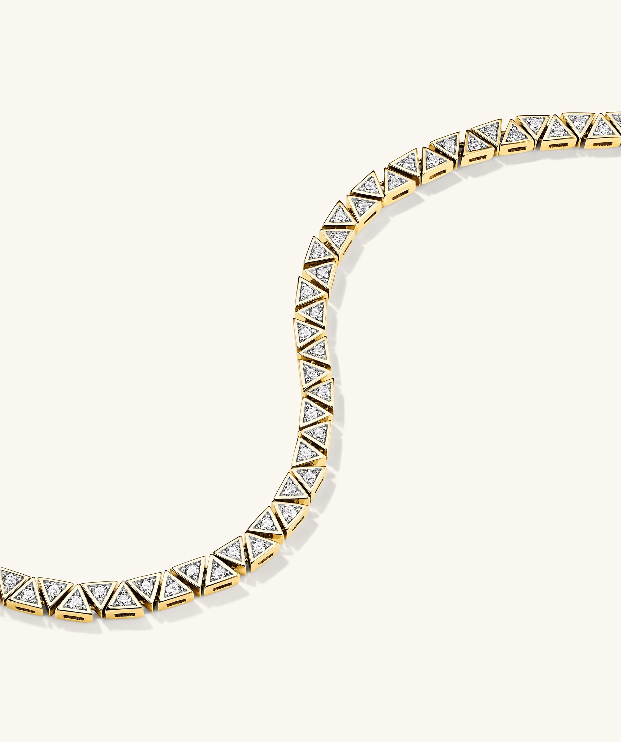 Patra Diamond Tennis Bracelet: A detailed view showcasing a gold bracelet adorned with diamonds, emphasizing its intricate craftsmanship and luxurious design.