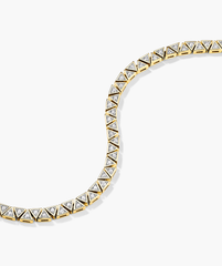 Patra Diamond Tennis Bracelet: A detailed view showcasing a gold bracelet adorned with diamonds, emphasizing its intricate craftsmanship and luxurious design.