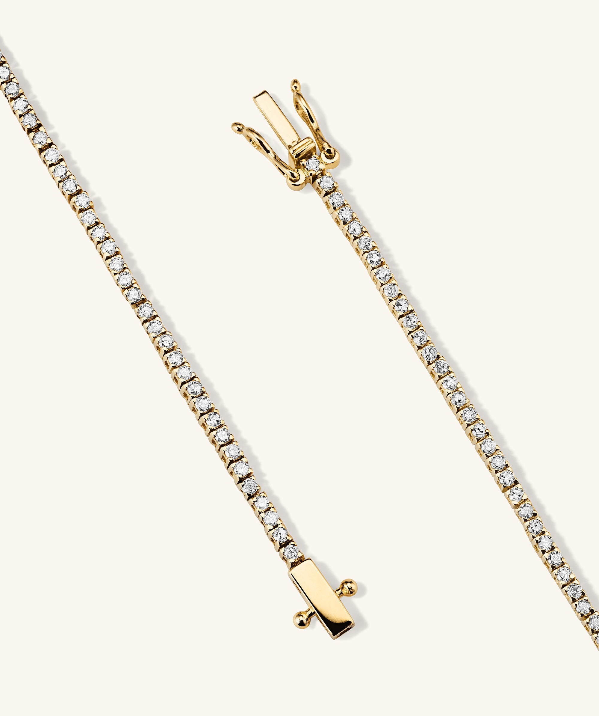 Diamond Tennis Bracelet 1.3mm: A close-up of a gold chain bracelet adorned with diamonds, featuring a secure clasp with safety arms for easy wear and removal.