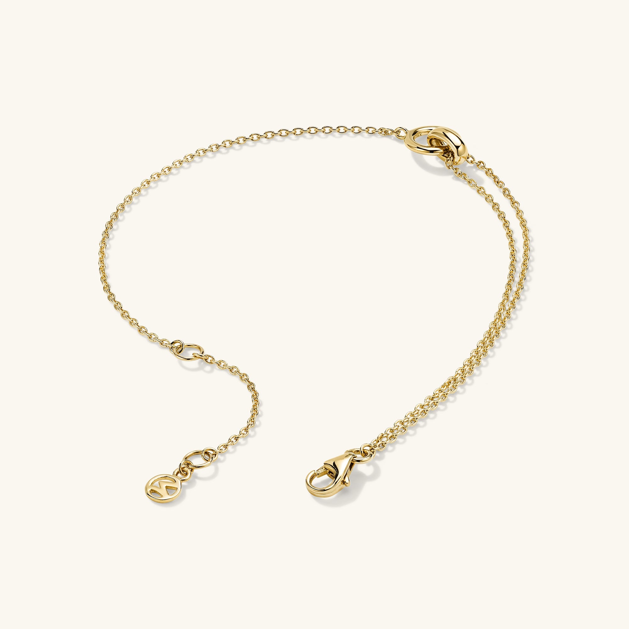 Linked Bracelet: A gold chain bracelet with two interlinked rings, featuring a small logo and clasp, symbolizing a strong personal bond.
