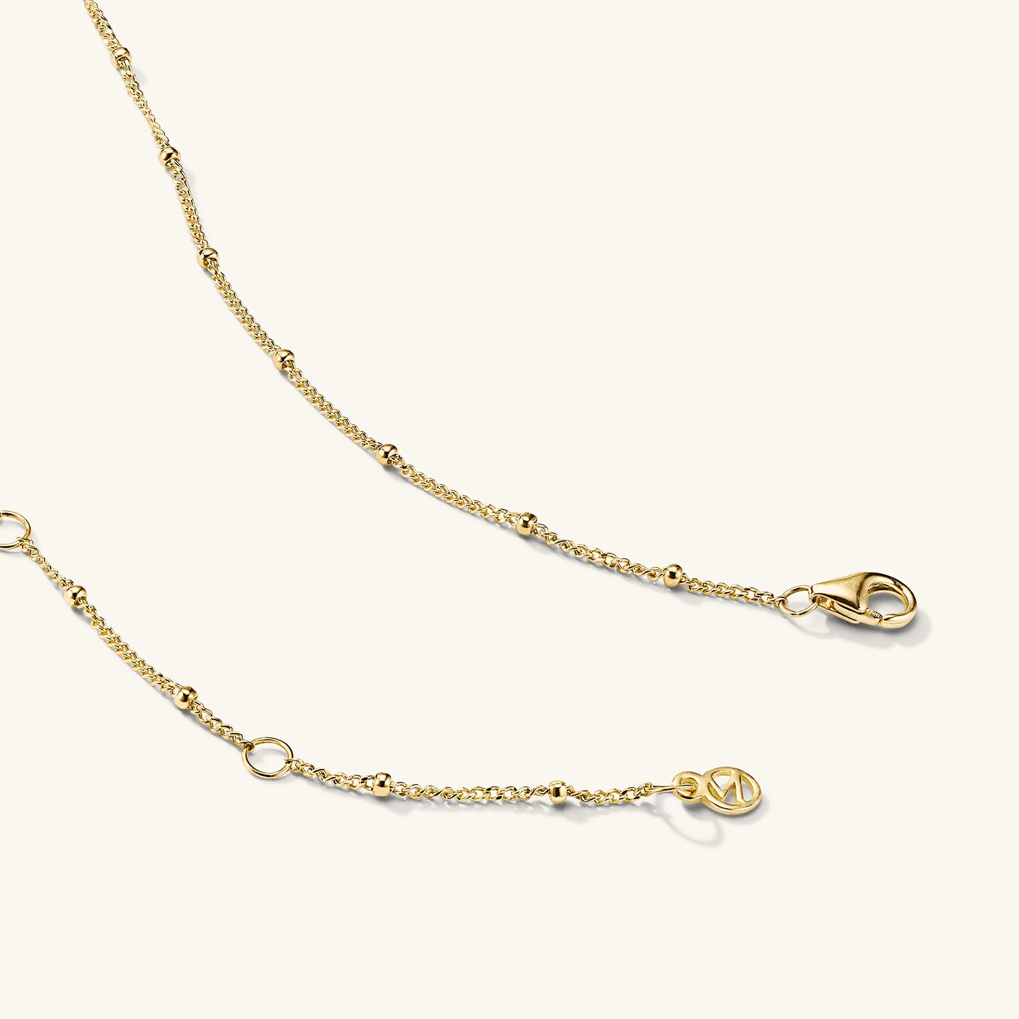 Spheres Chain Necklace: A minimalistic gold chain featuring a clasp, perfect for versatile wear on any occasion.