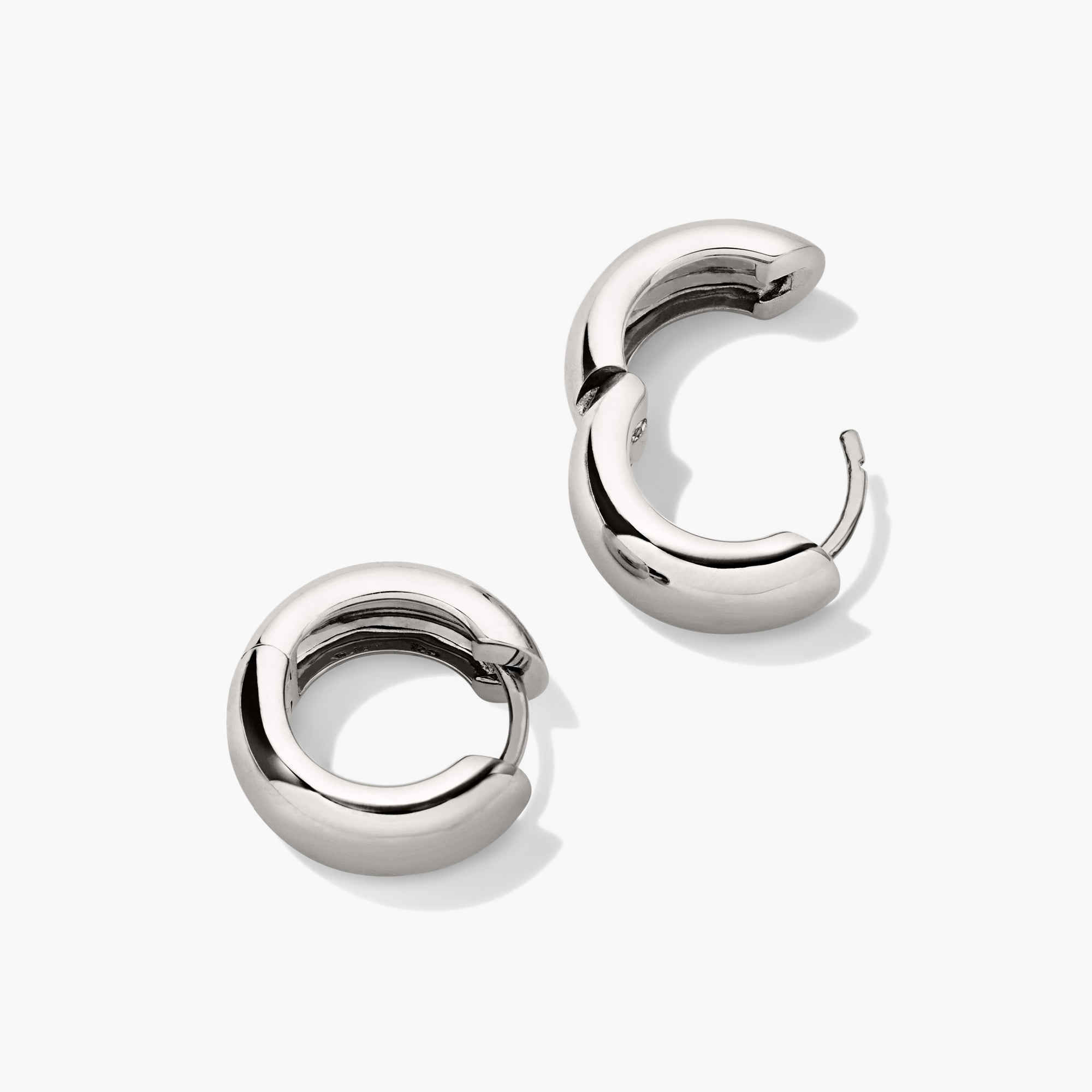 Chunky Medium Hoops: A pair of silver, pillowy hoop earrings with curved edges, featuring a secure clicker closure.