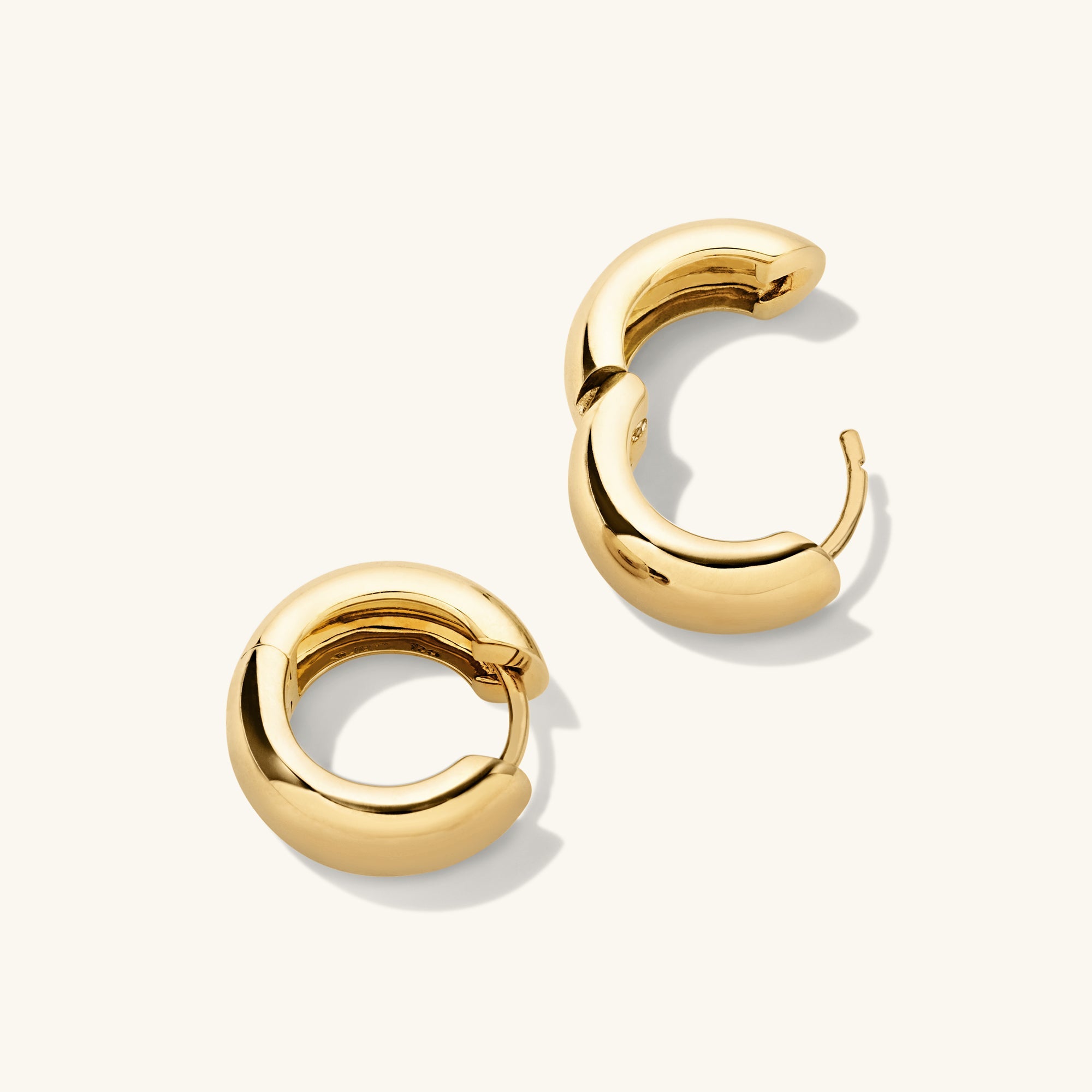 Chunky Medium Hoops: A pair of gold hoop earrings with pillowy, curved edges and a secure clicker closure for comfort and stacking.