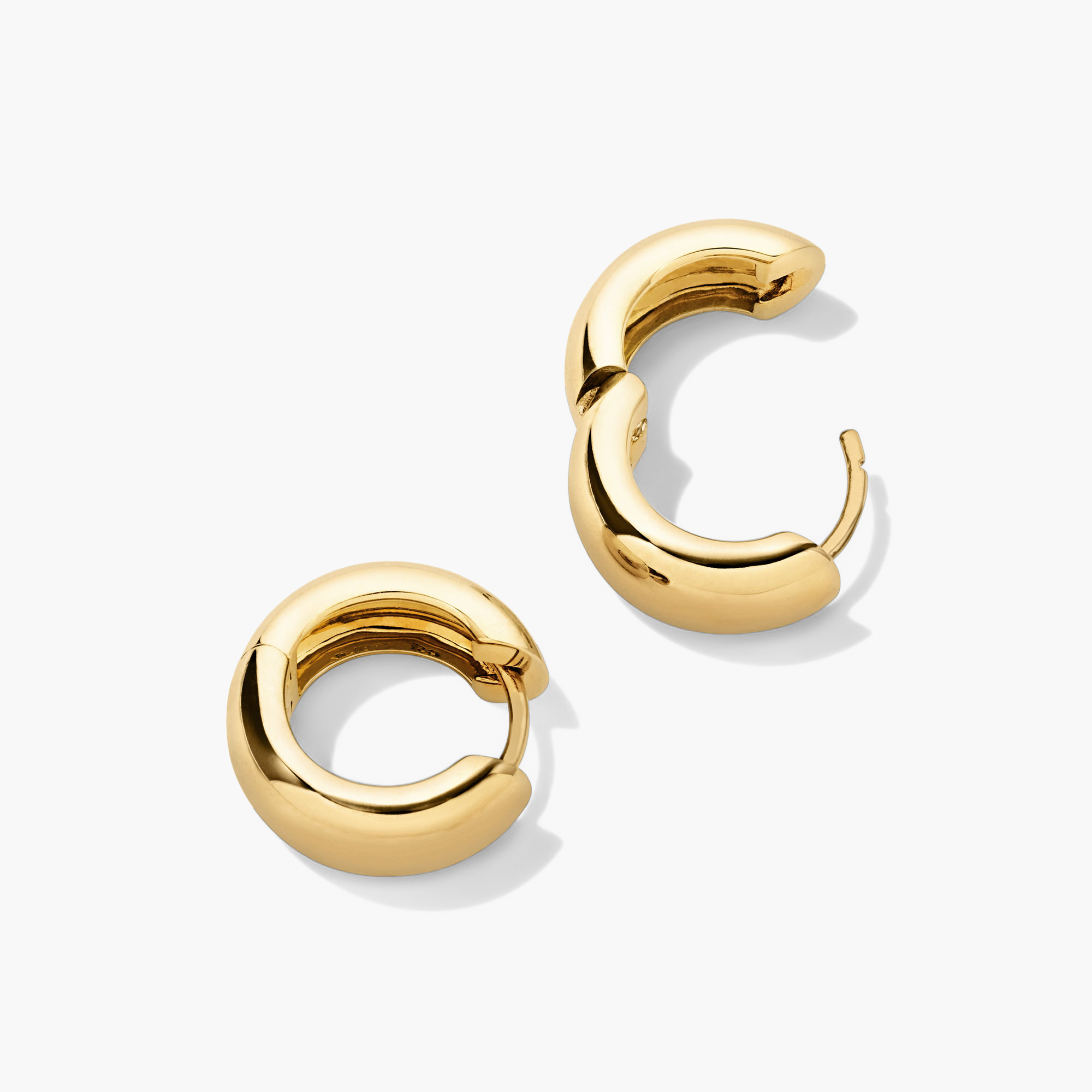 Chunky Medium Hoops: A pair of gold hoop earrings with pillowy, curved edges and a secure clicker closure for comfort and stacking.