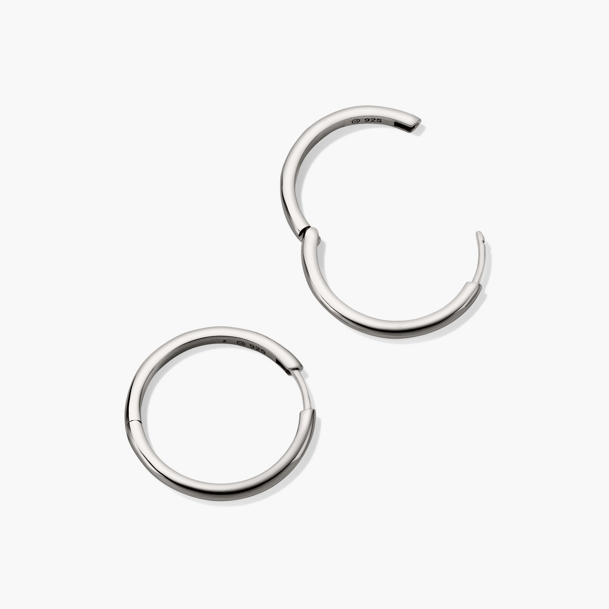 Tube Large Hoops: A pair of bold, silver hoop earrings with a modern tubular design and secure clicker closure. Lightweight for effortless wear.