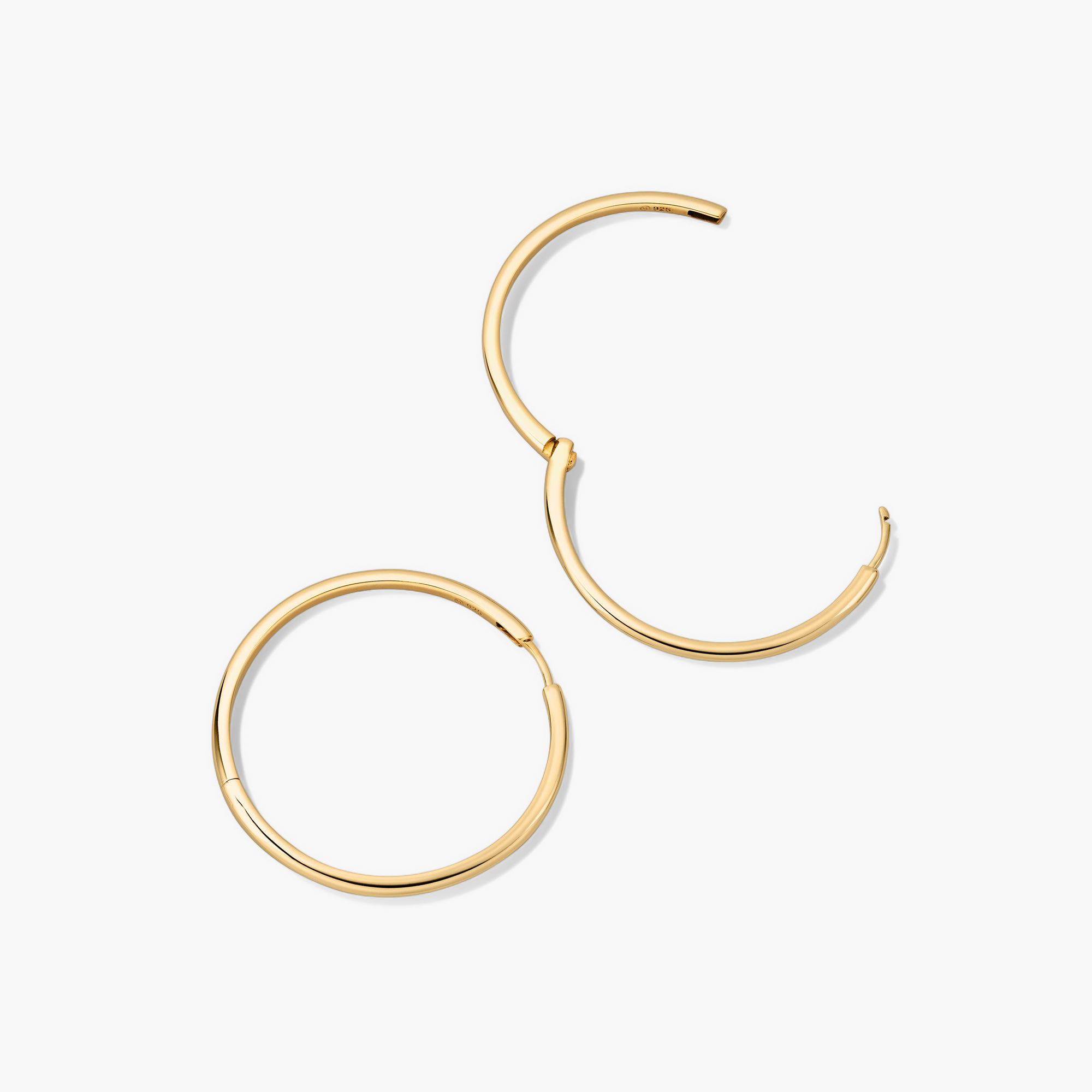 Tube Oversized Hoops: A pair of bold, modern gold tube hoop earrings with a clicker closure for comfort and security.