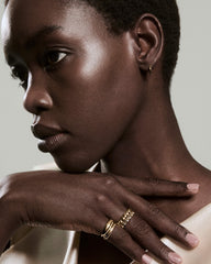 Classic Charlotte Stacker Bundle on left hand, featuring a smooth band and beaded-and-stone ring, paired with a gold hoop earring.
