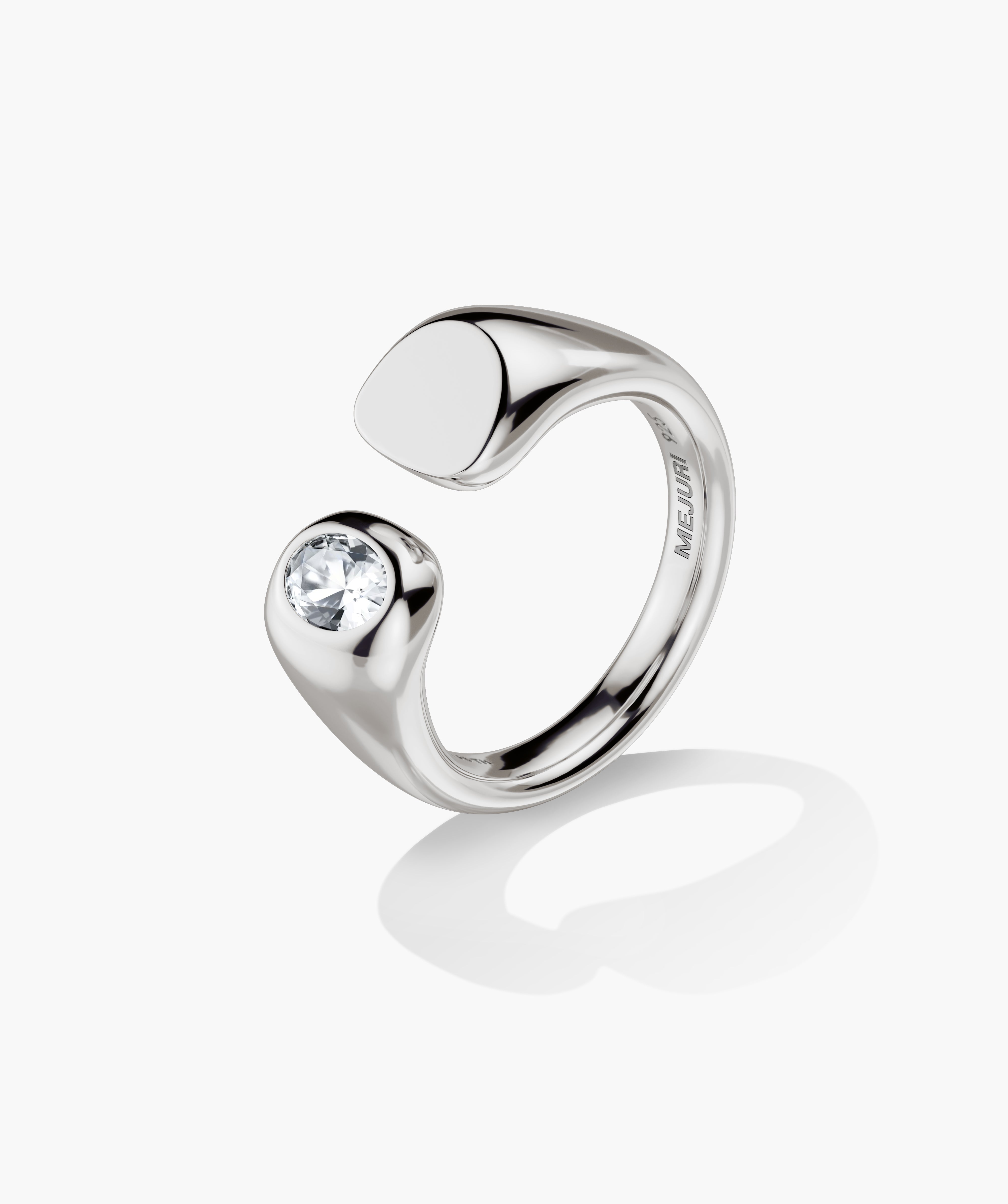 Noa Open Signet Pinky Ring features a minimalist metal band with a diamond-set tip and an oval pad, stamped MEJURI inside.