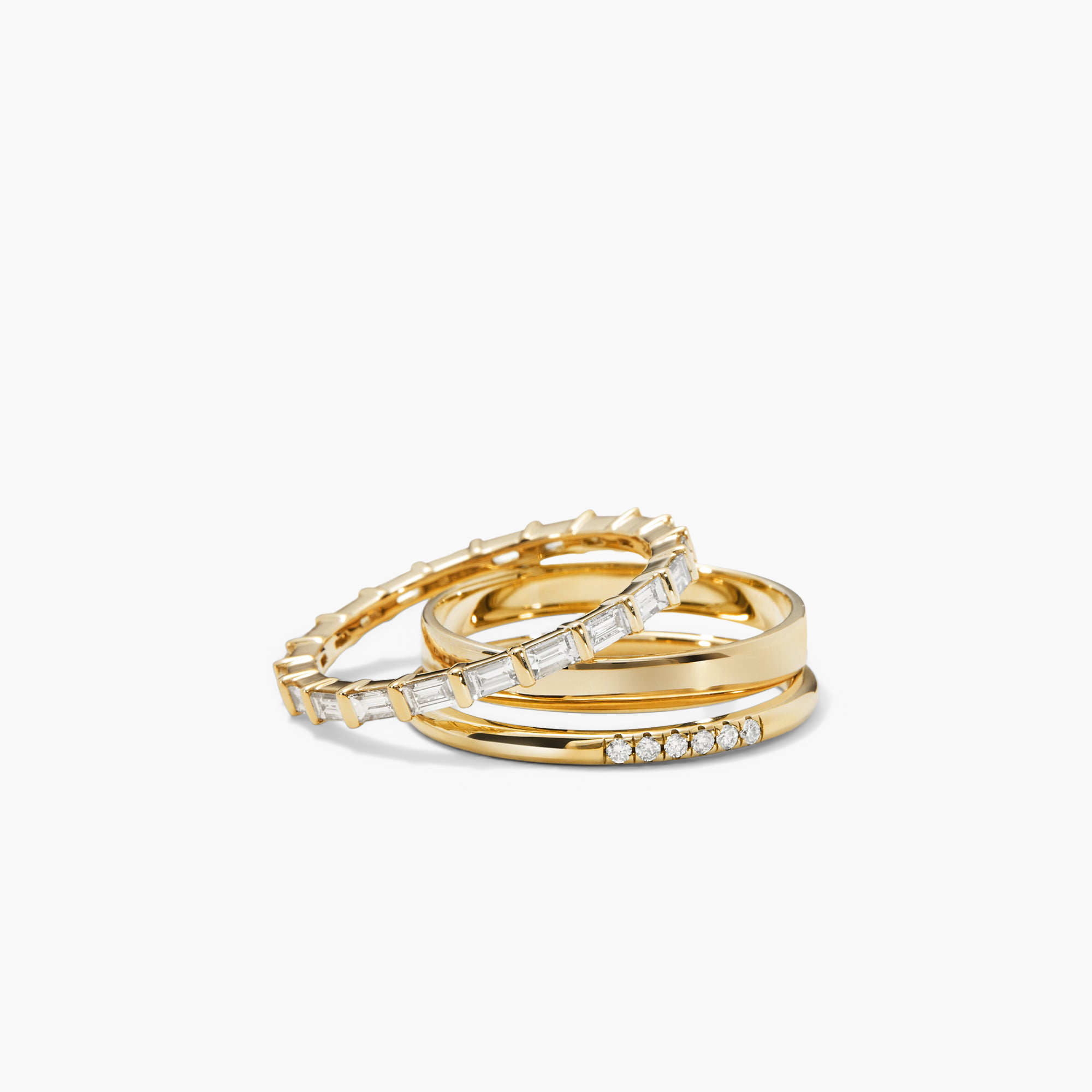 Stack of gold rings with baguette-cut diamonds in an eternity band style, featuring a 14k solid gold band and Kimberley Process-certified diamonds.