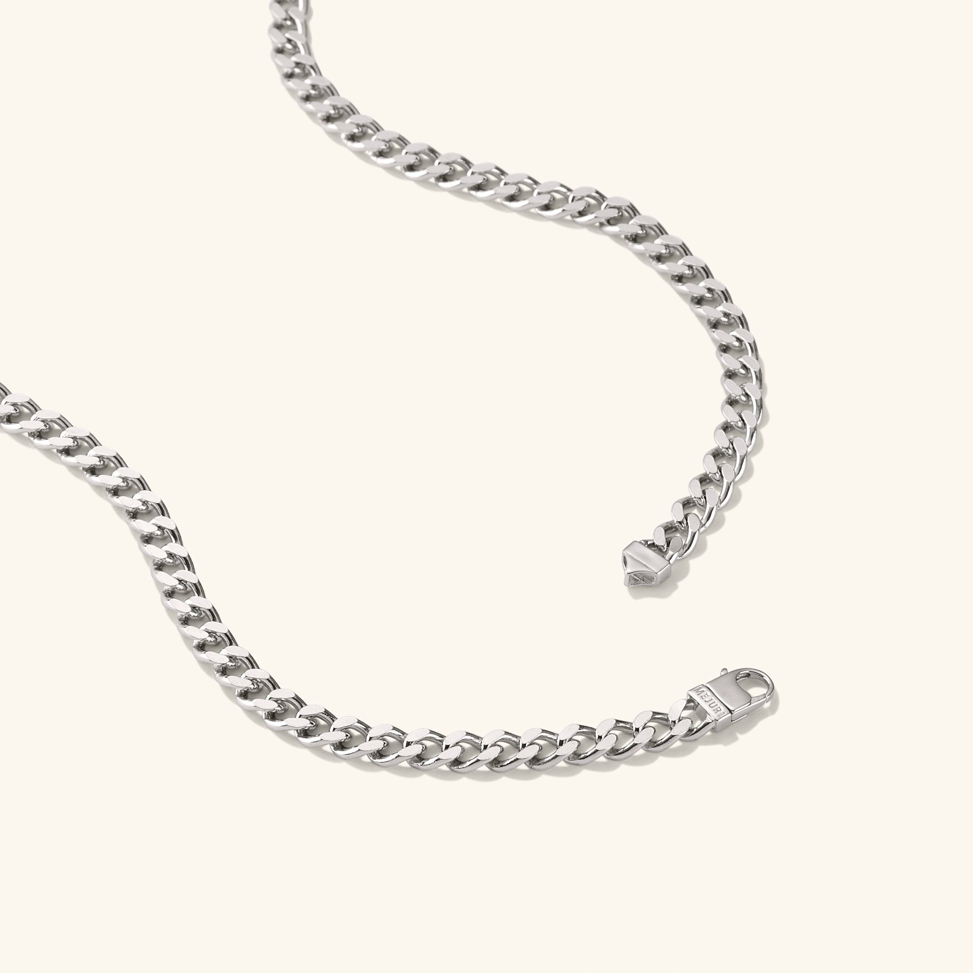 5mm Curb Chain Necklace: A silver chain with a close-up of its metal clasp, designed for versatile everyday wear and statement style.