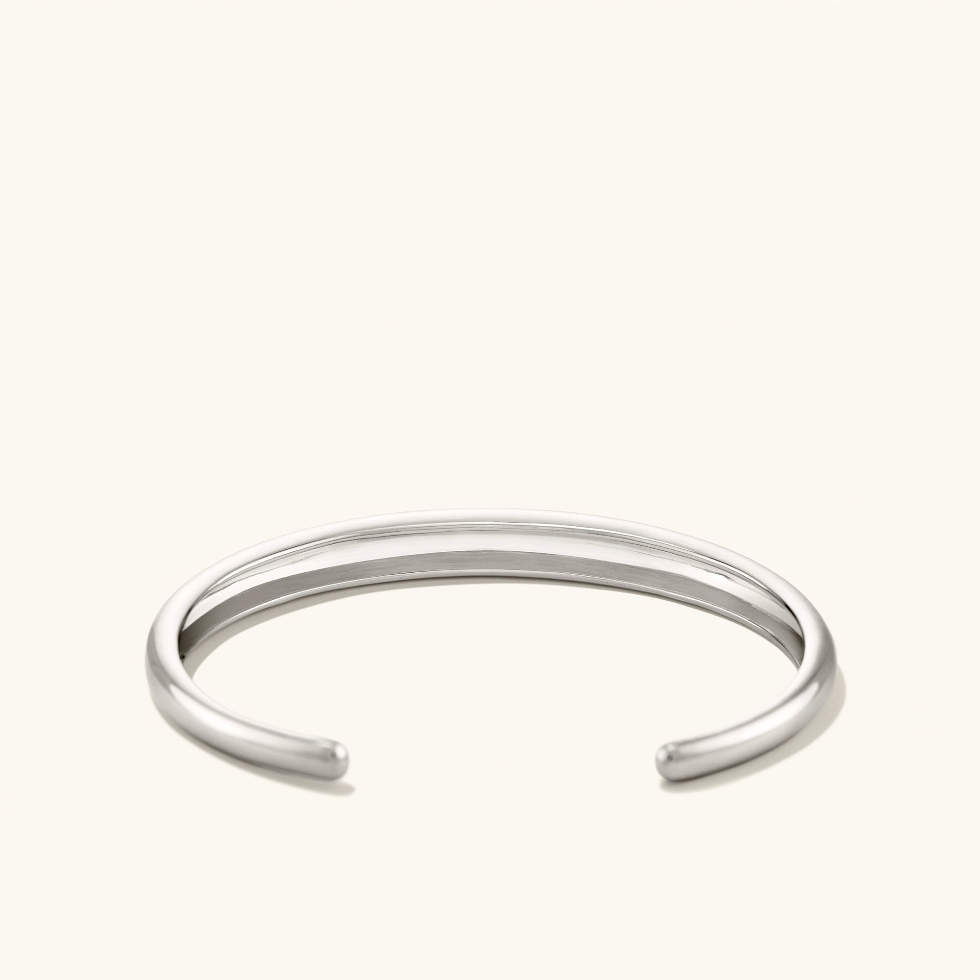 Silver DÃ´me Cuff Bracelet on white background, showcasing intricate design inspired by a ray of sunshine.
