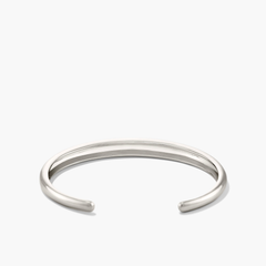 Silver DÃ´me Cuff Bracelet on white background, showcasing intricate design inspired by a ray of sunshine.