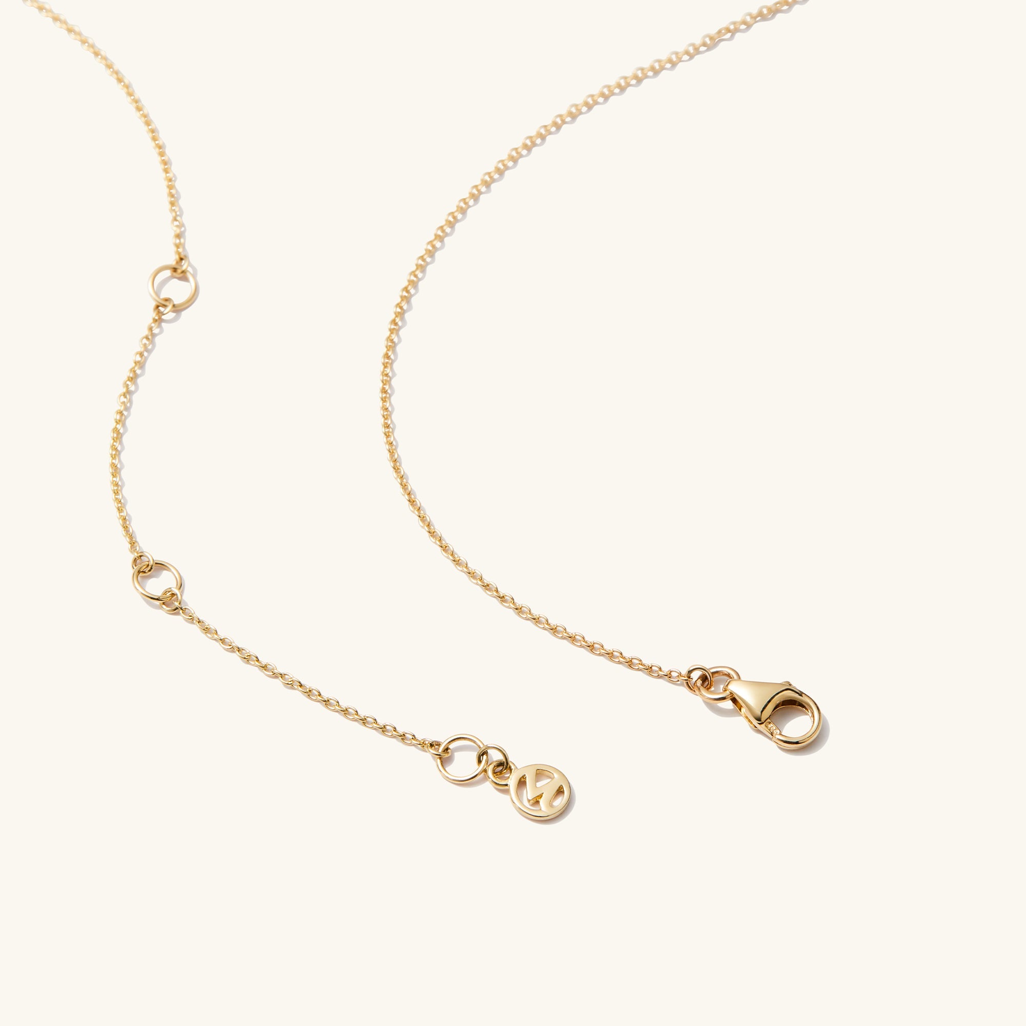 Baguette Emerald Bar Necklace: A close-up of a 14k solid gold chain featuring a handcrafted baguette emerald pendant with precise cuts and unique inclusions.