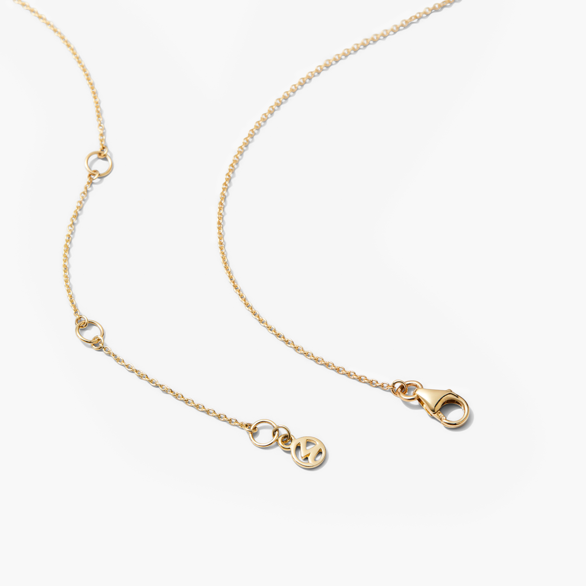 Baguette Emerald Bar Necklace: A close-up of a 14k solid gold chain featuring a handcrafted baguette emerald pendant with precise cuts and unique inclusions.