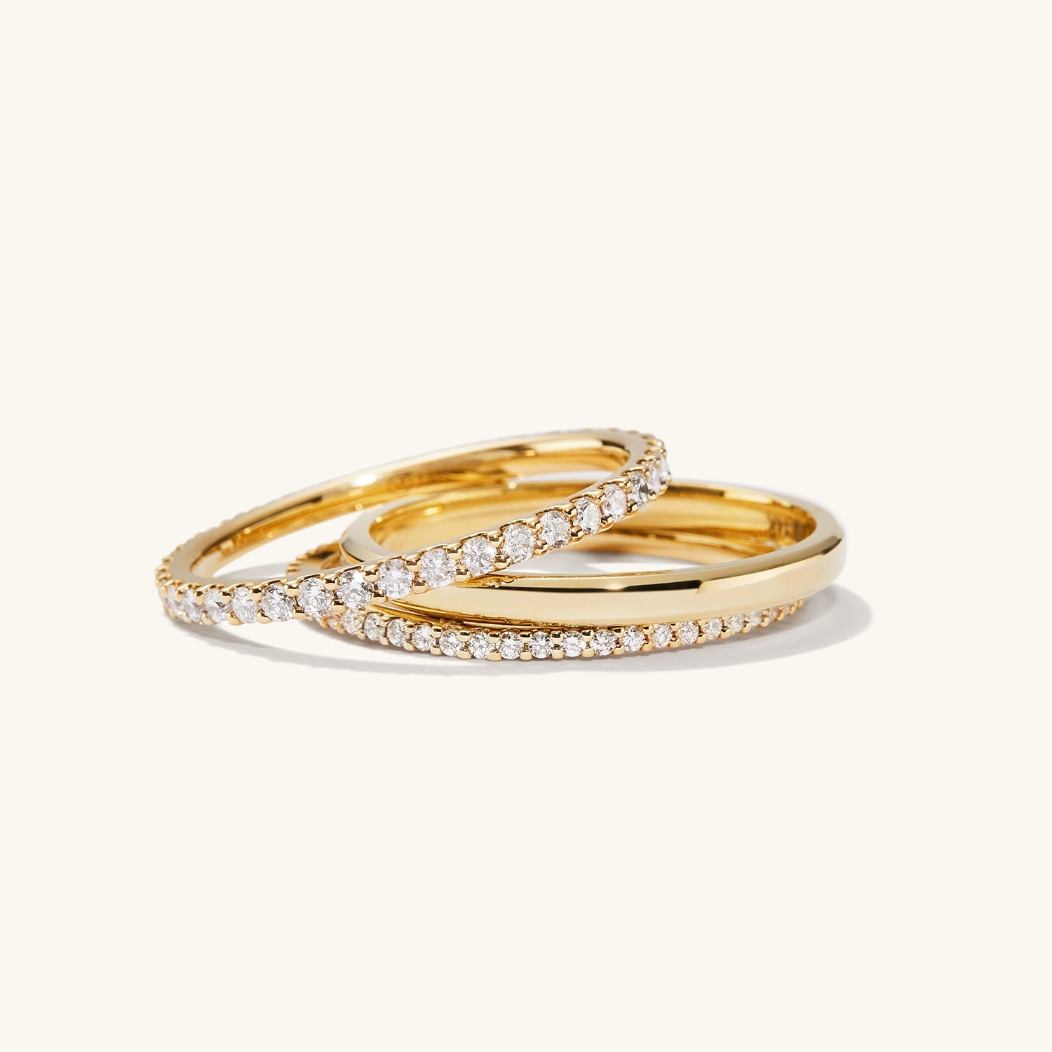 Diamond Eternity Band: A pair of slim gold rings with hand-set diamonds in open prongs, showcasing a timeless, elegant design for lasting wear.