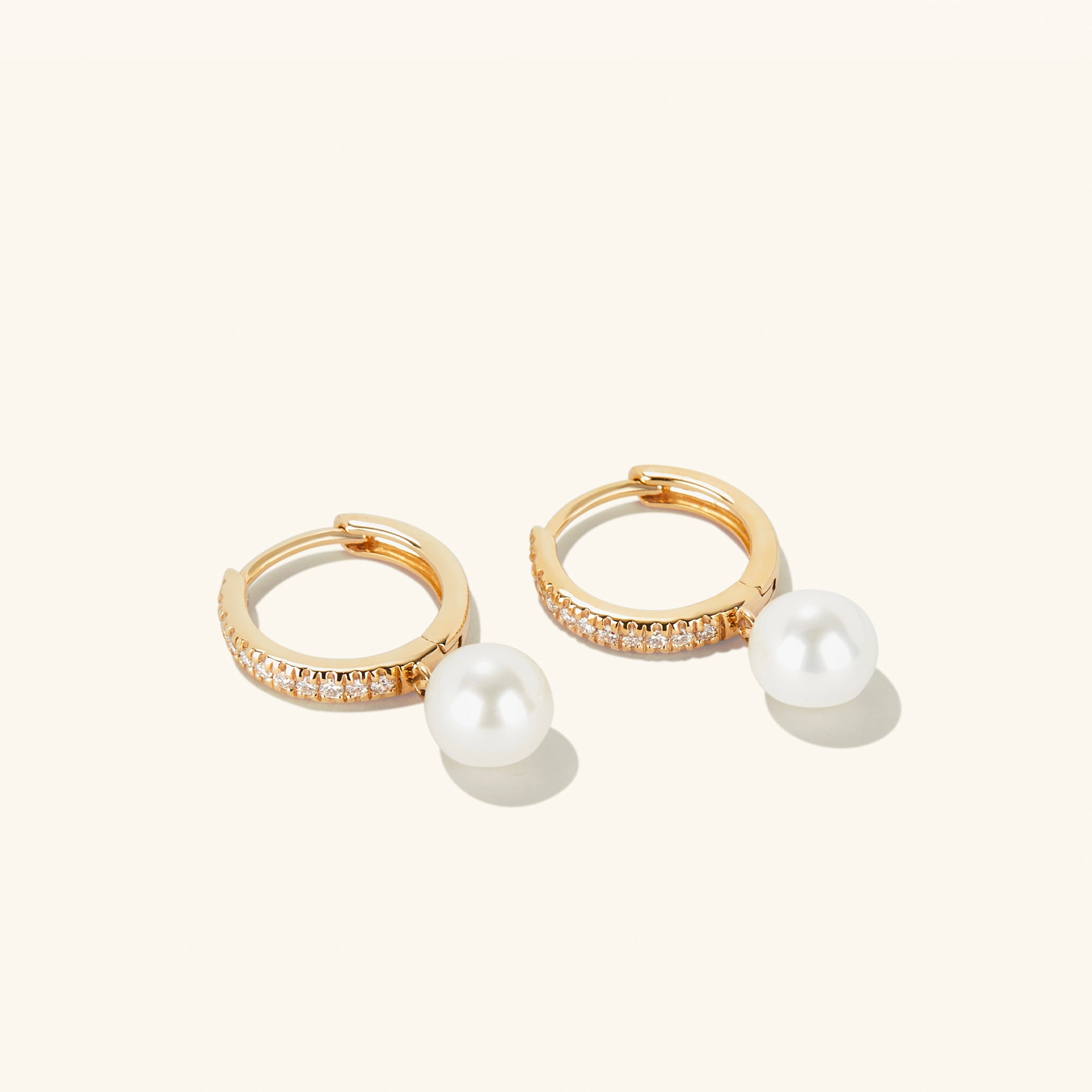 PavÃ© Diamond Pearl Huggies: A pair of 14k gold hoop earrings featuring 22 pavÃ©-set diamonds and a round freshwater pearl.