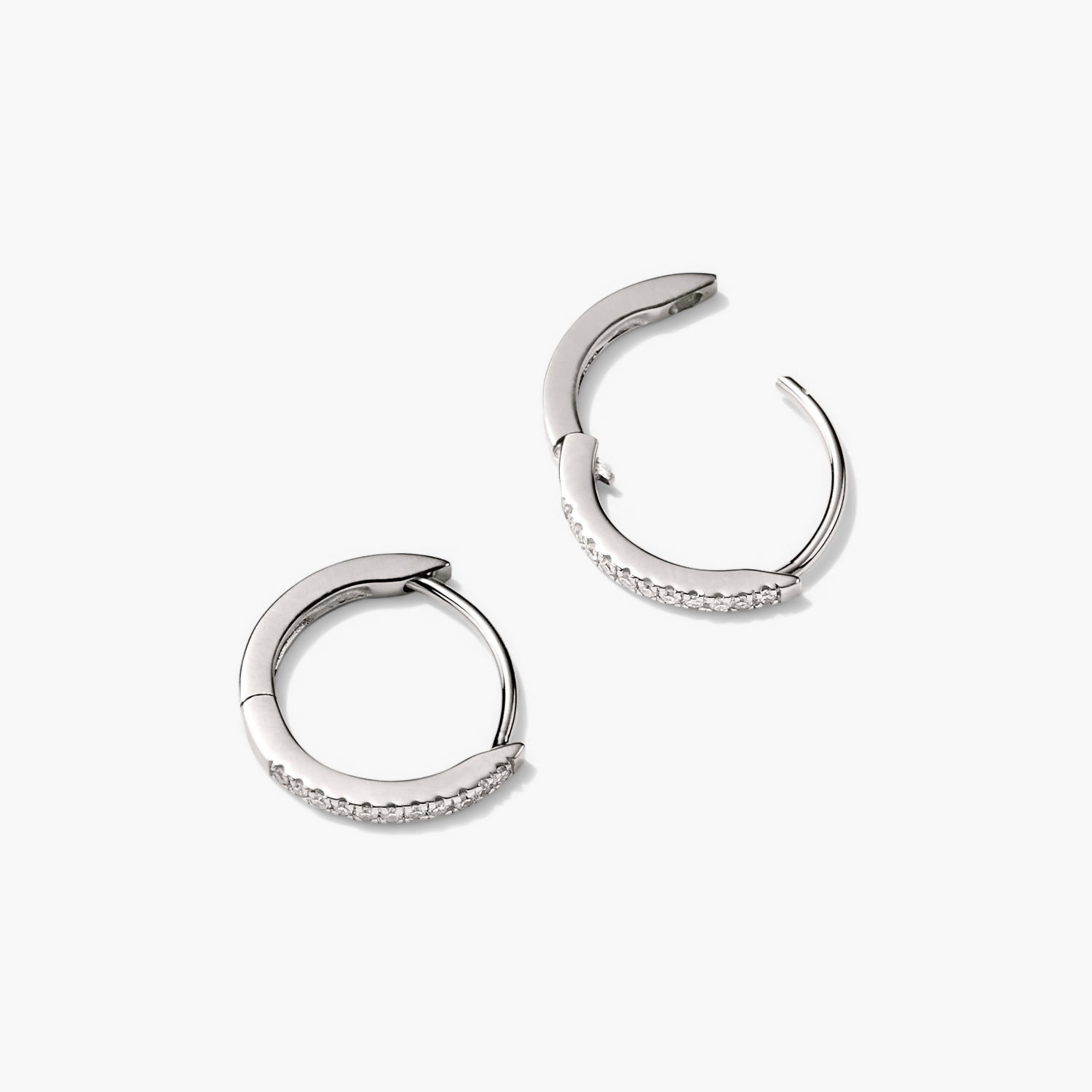 PavÃ© Diamond Huggie Hoops: a pair of silver earrings with pavÃ© diamonds, designed for versatile wear, handcrafted in recycled 14k solid gold.