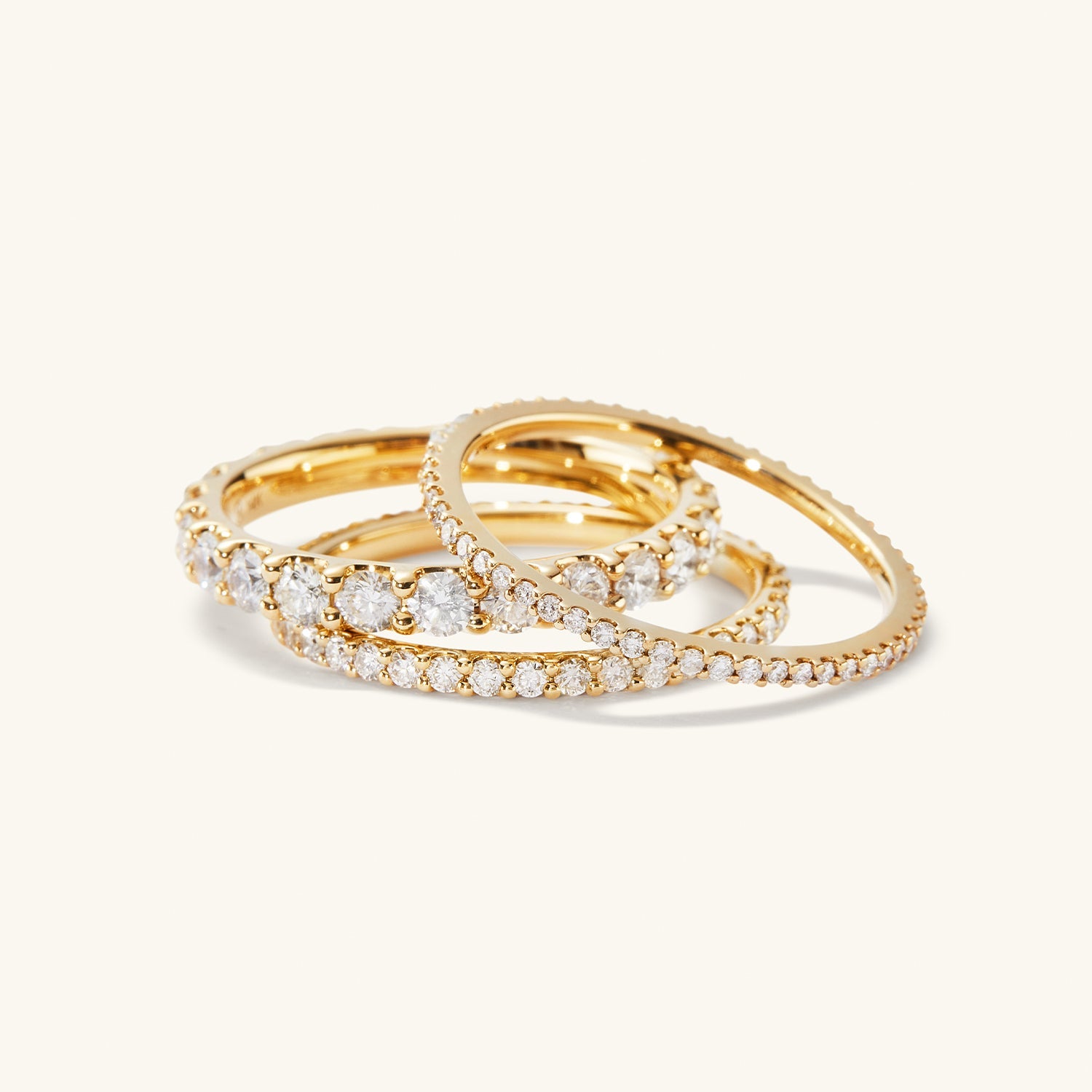 Slim Diamond Eternity Band: A stack of slim gold rings, each adorned with hand-set diamonds in open prongs, showcasing a timeless elegance.