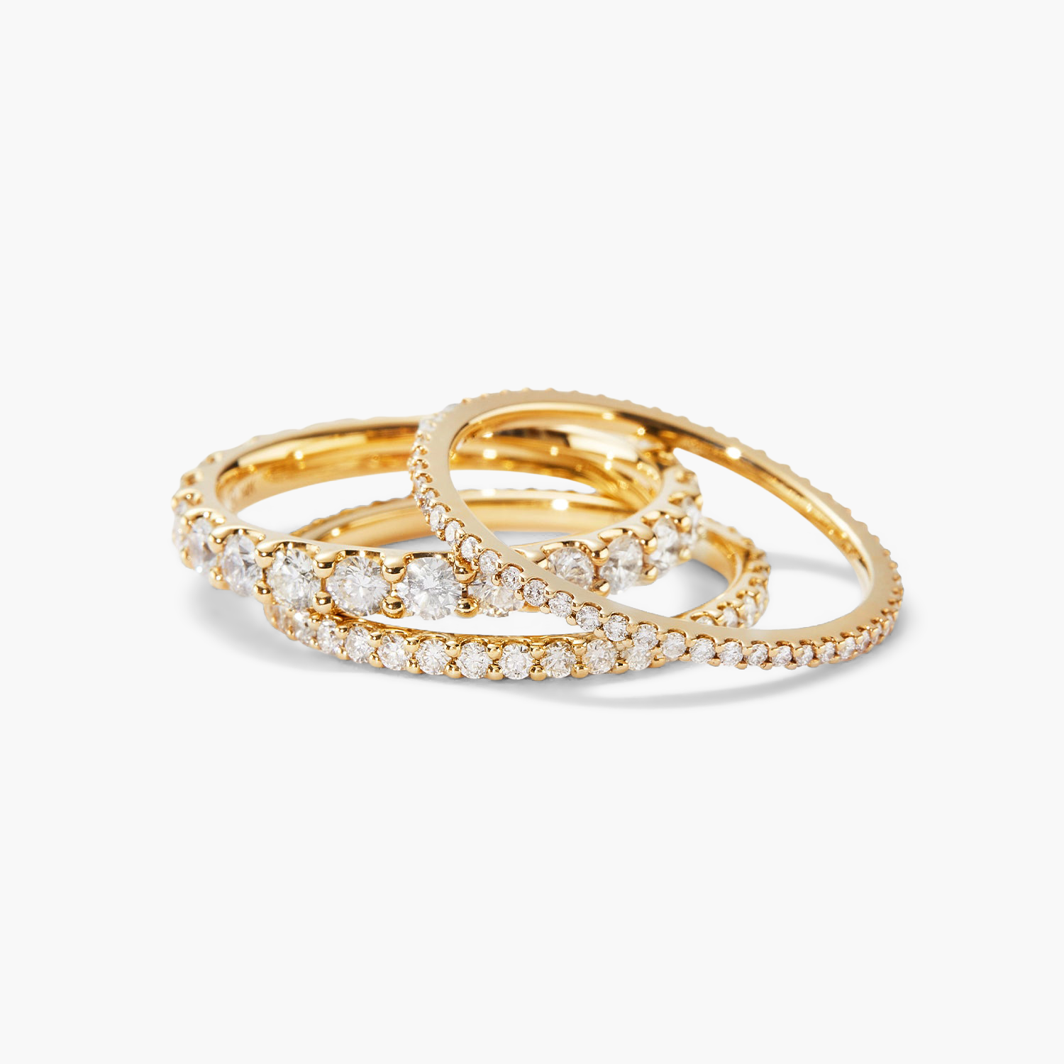 Slim Diamond Eternity Band: A stack of slim gold rings, each adorned with hand-set diamonds in open prongs, showcasing a timeless elegance.