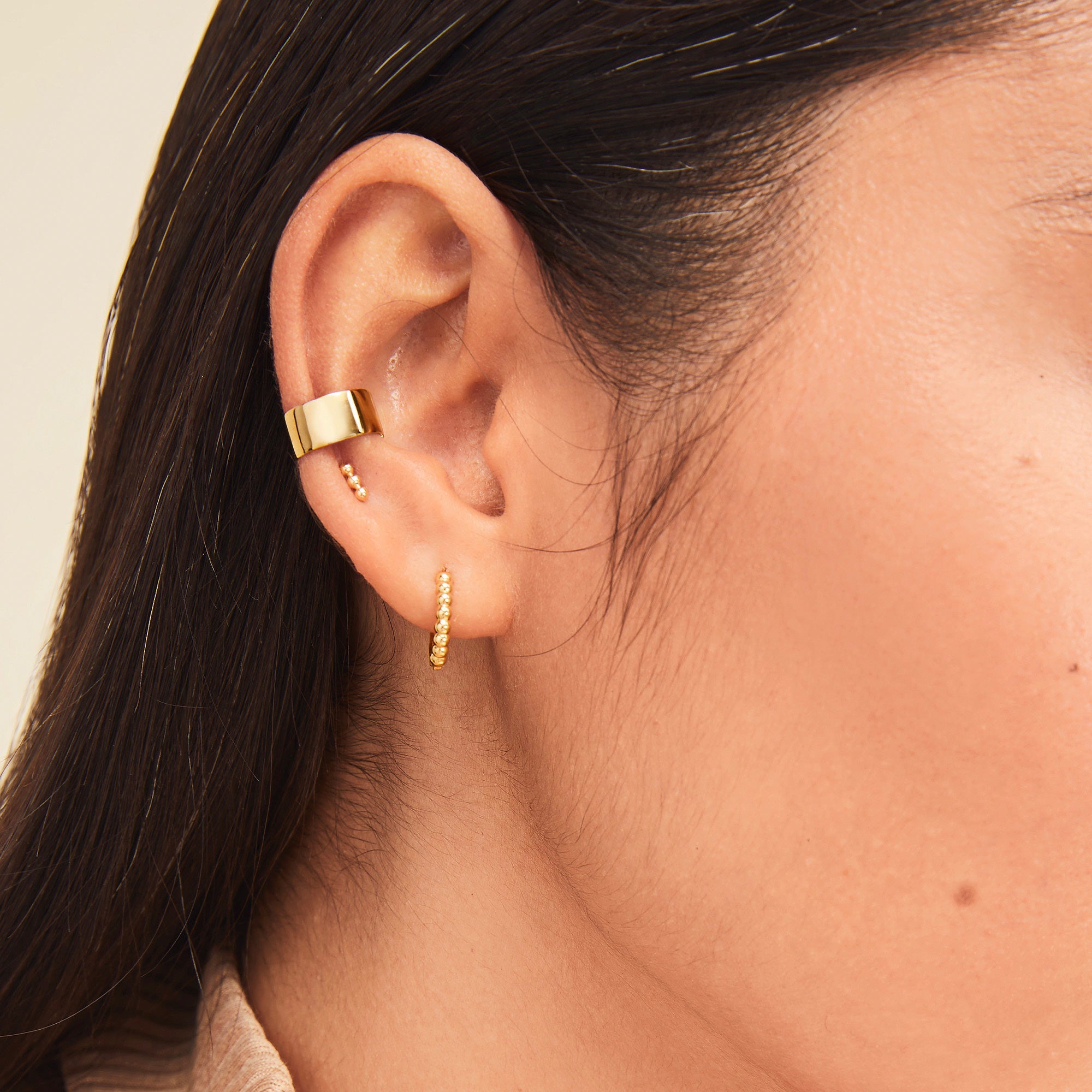 Daily Ear Cuff showcased in a close-up of a woman's ear, highlighting its polished vermeil finish and high-impact shine for a classic, versatile look.