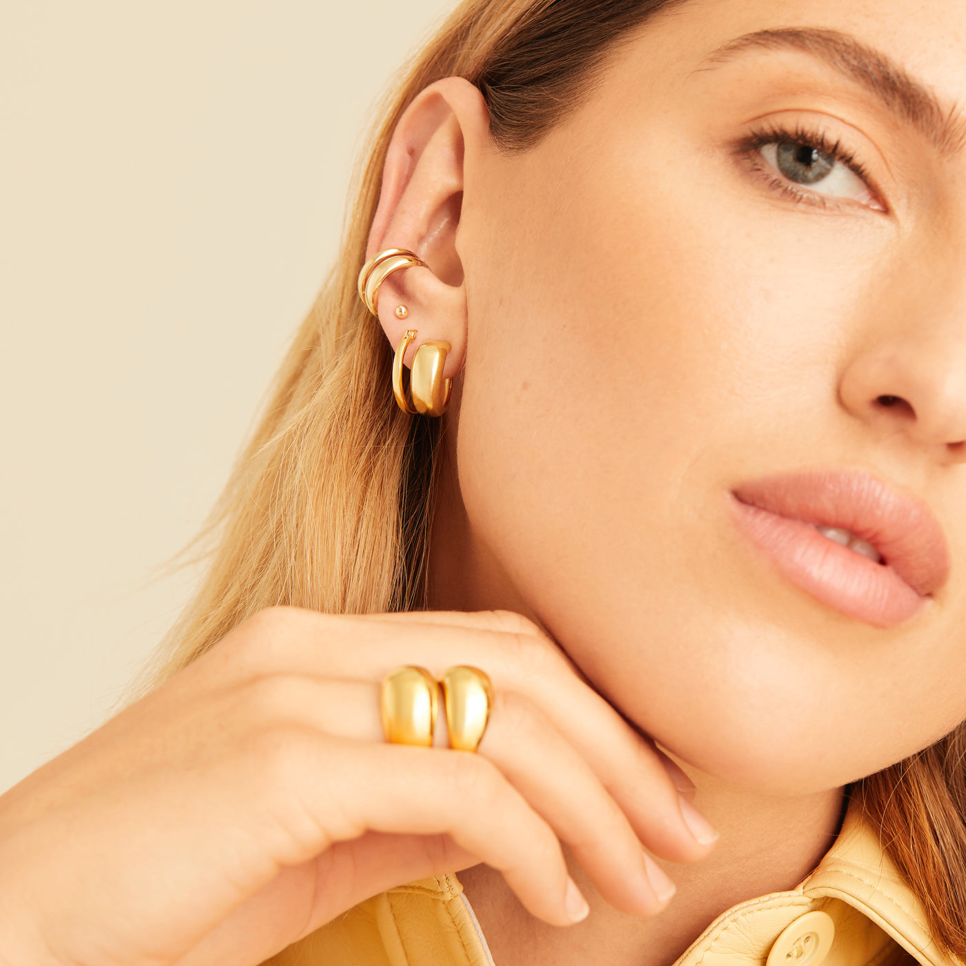 Close-up of a woman wearing the Duet Ear Cuff, a handcrafted gold vermeil piece, showcasing its elegant design on her ear.