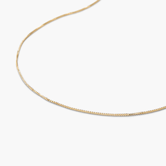 Baby Box Chain Necklace: A delicate gold chain, light as air, with a classic box design, showcased on a white surface. Perfect for those with refined taste.