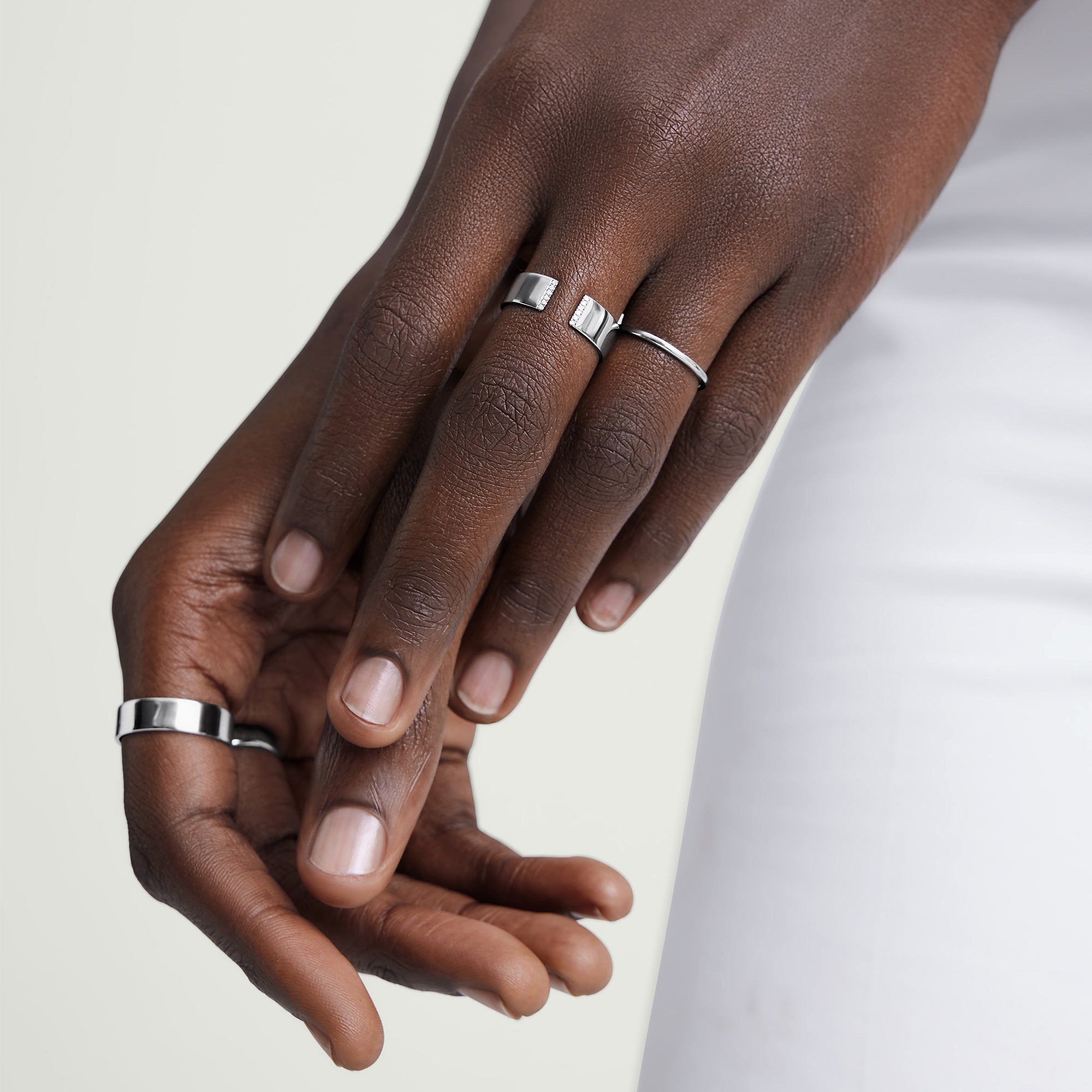 Close-up of hands wearing the Stacker Ring, showcasing its simple, versatile design suitable for any collection or outfit.