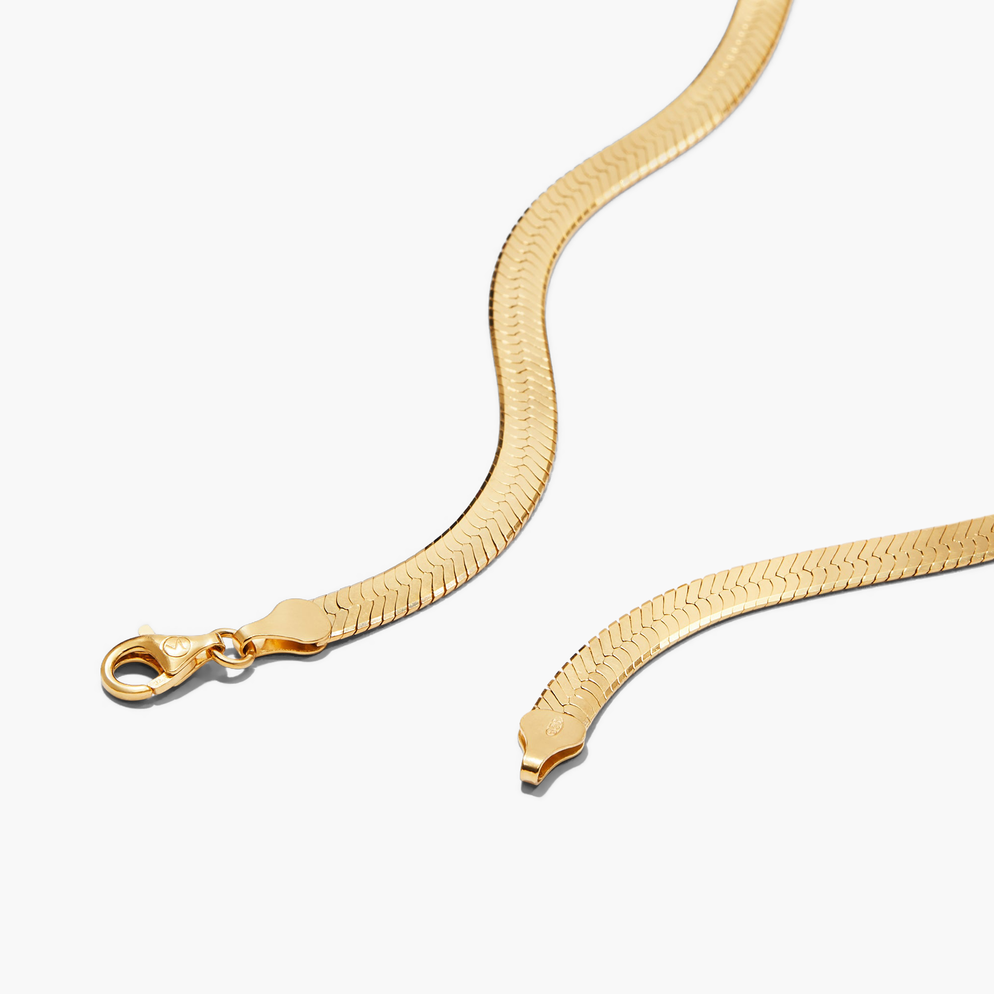 Bold Herringbone Chain Necklace with a clasp, close-up shot showing the intricate gold herringbone pattern. Available in two lengths for versatile styling.