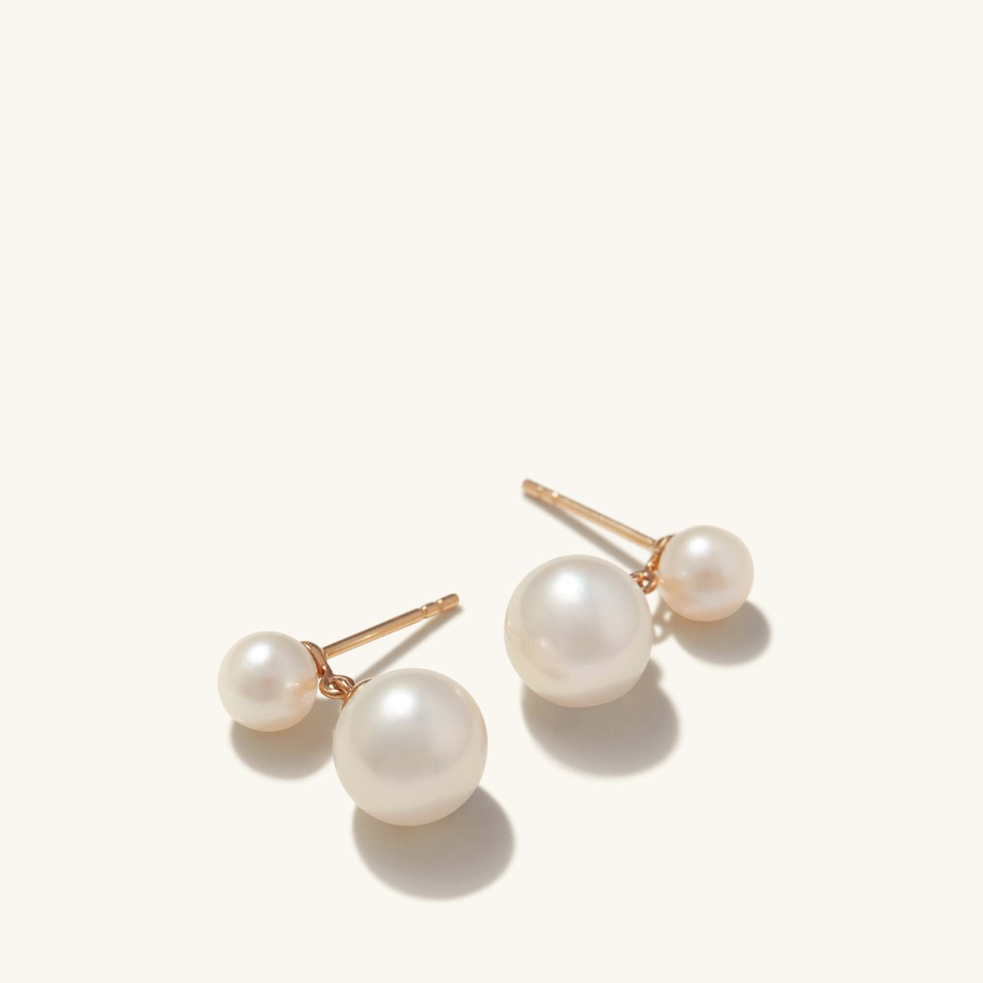 Essential Pearl Earrings, a pair of handcrafted 14k solid gold earrings featuring lustrous pearls in three finishes, showcased in a detailed close-up.