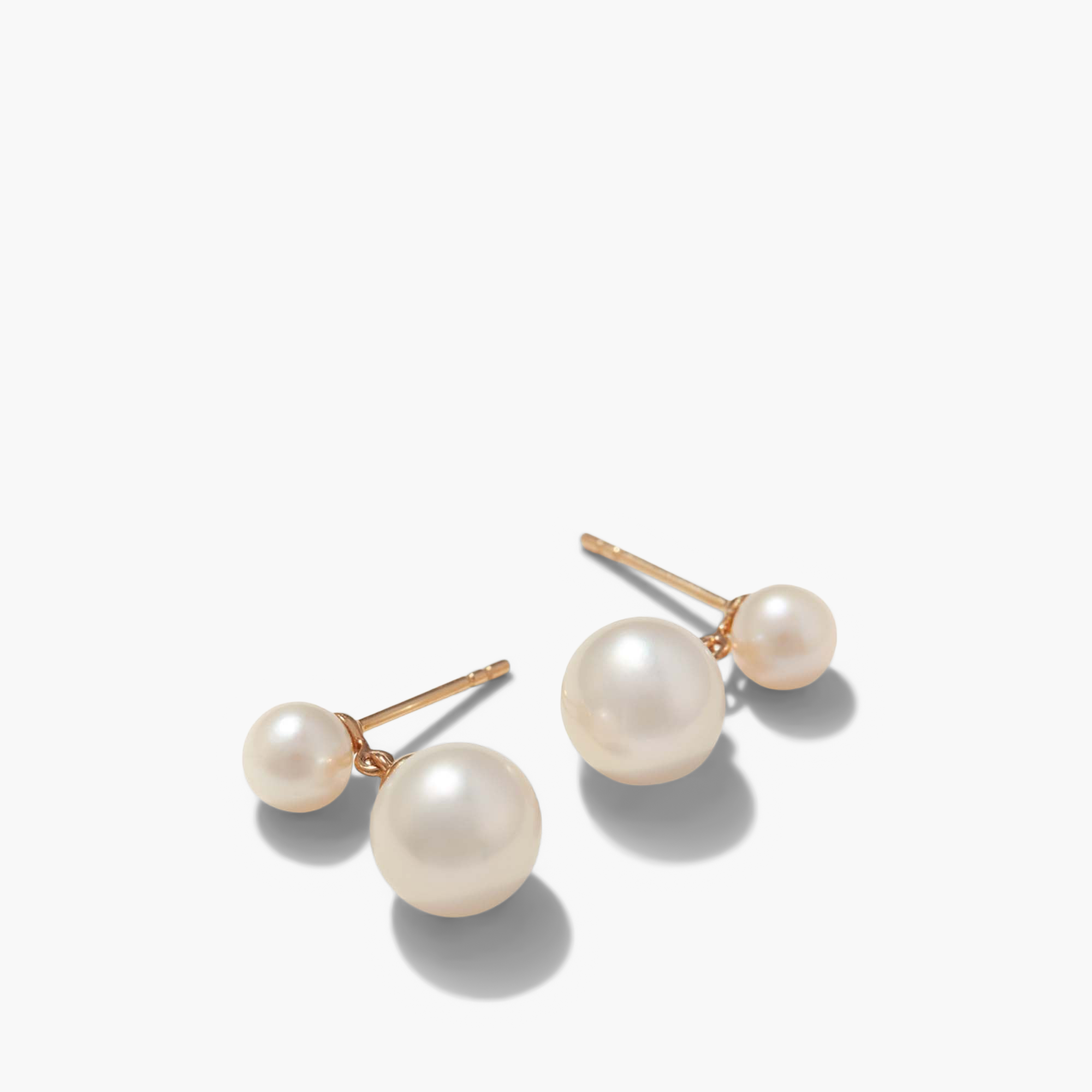 Essential Pearl Earrings, a pair of handcrafted 14k solid gold earrings featuring lustrous pearls in three finishes, showcased in a detailed close-up.