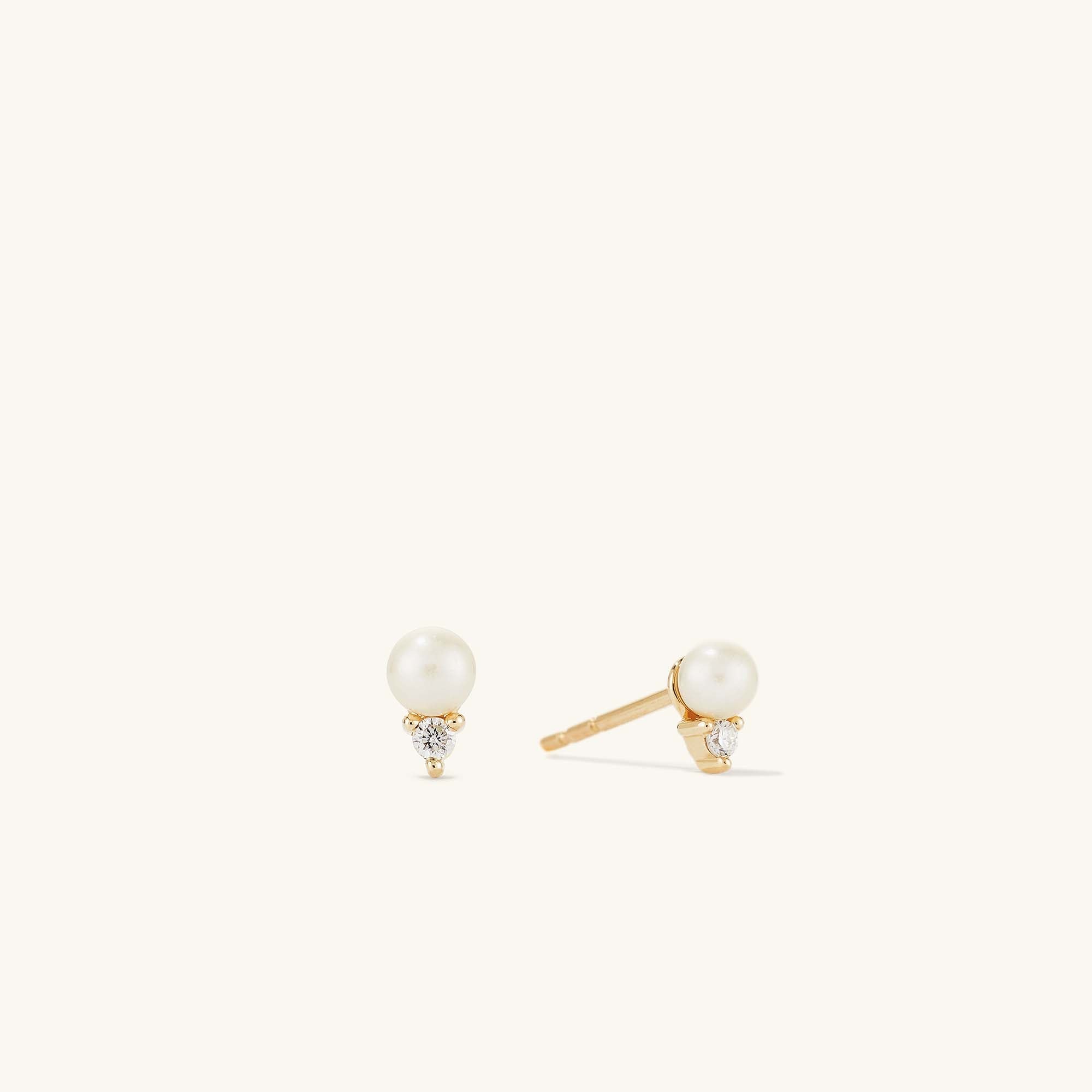 Diamond Pearl Studs featuring a 14k gold setting, adorned with a central pearl surrounded by small diamonds for an elegant, timeless look.